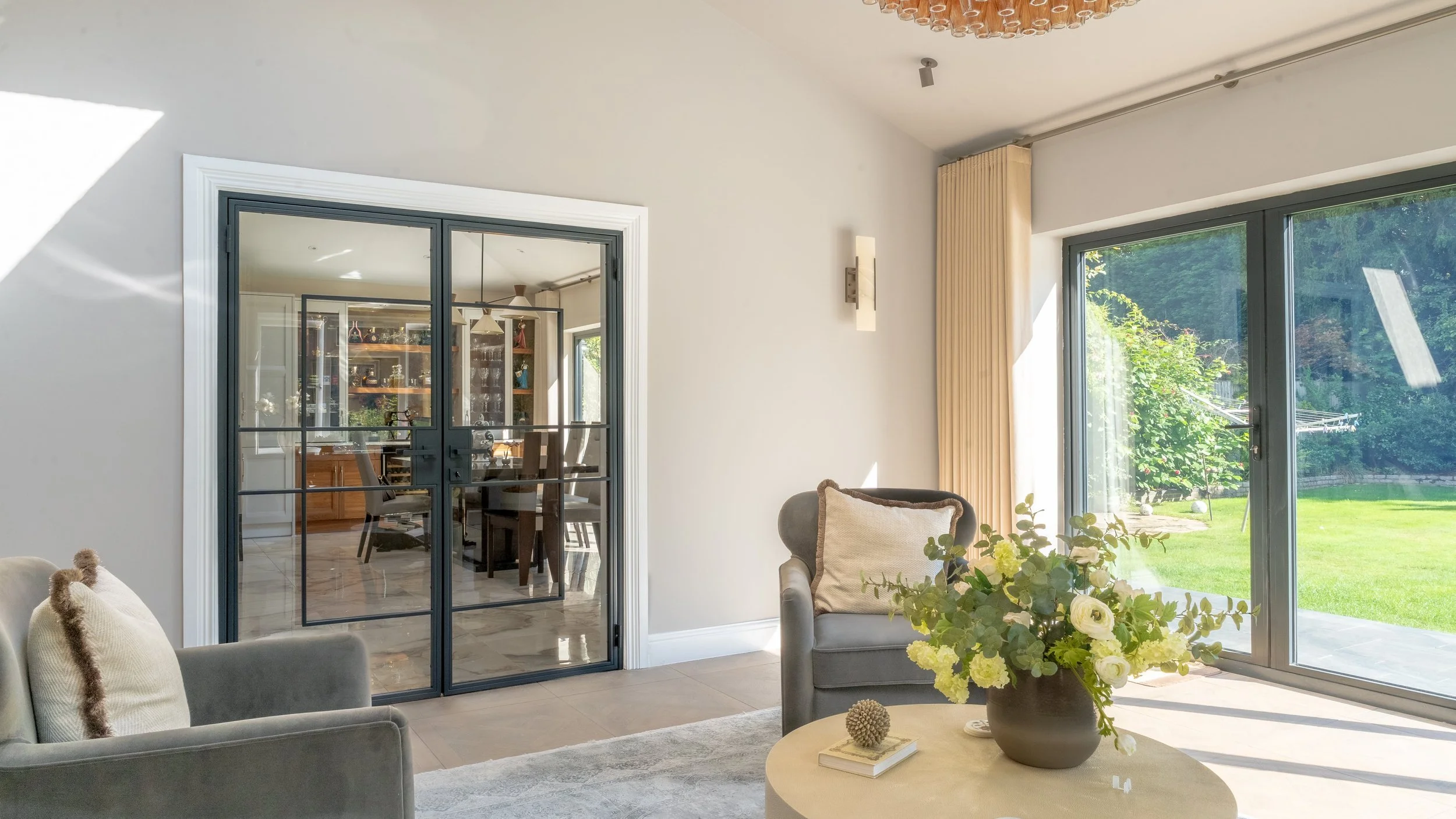 Steel framed internal door between hallway and living room in a luxury home.