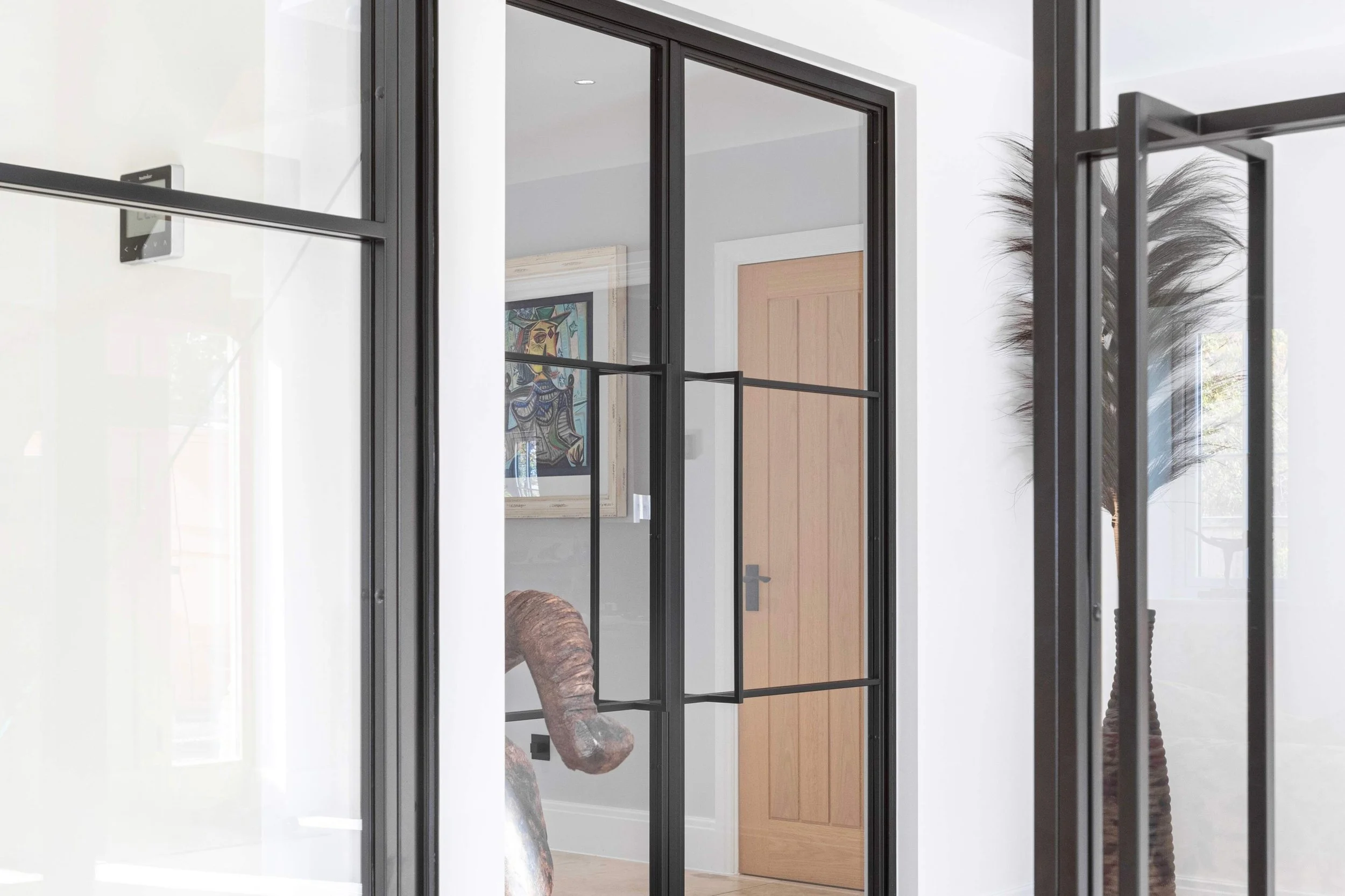 Detailed view of a steel-framed door and handle in a luxury residential setting