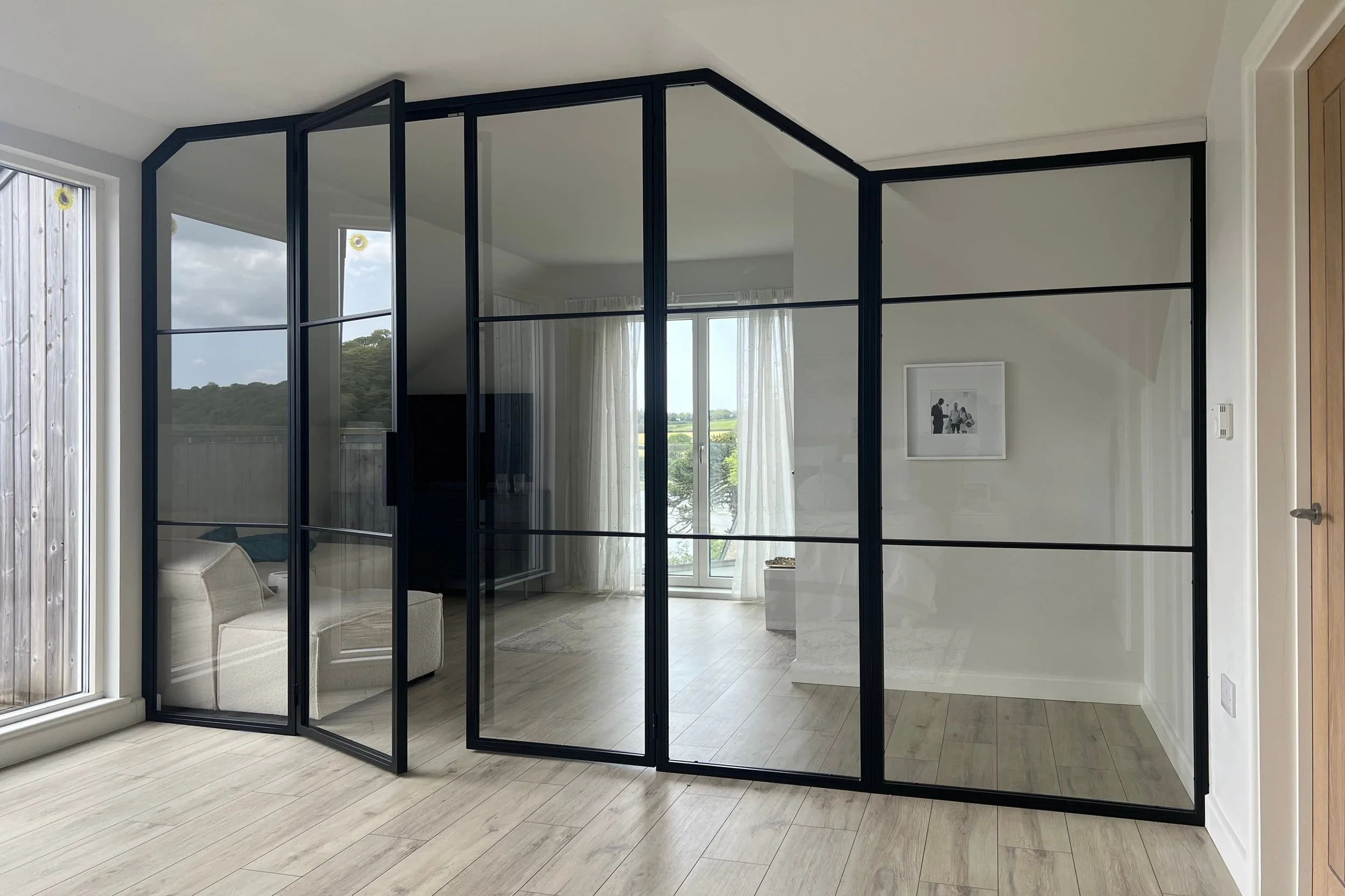 Open bespoke steel internal doors connecting two zones within a luxury open plan home by Joshua James.