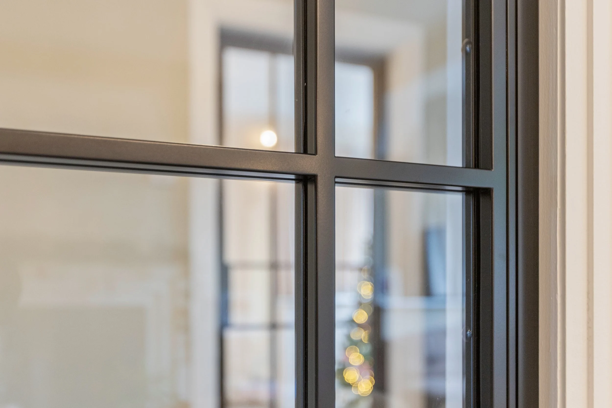 Warm winter lighting shining through a steel-framed double door set at Christmas