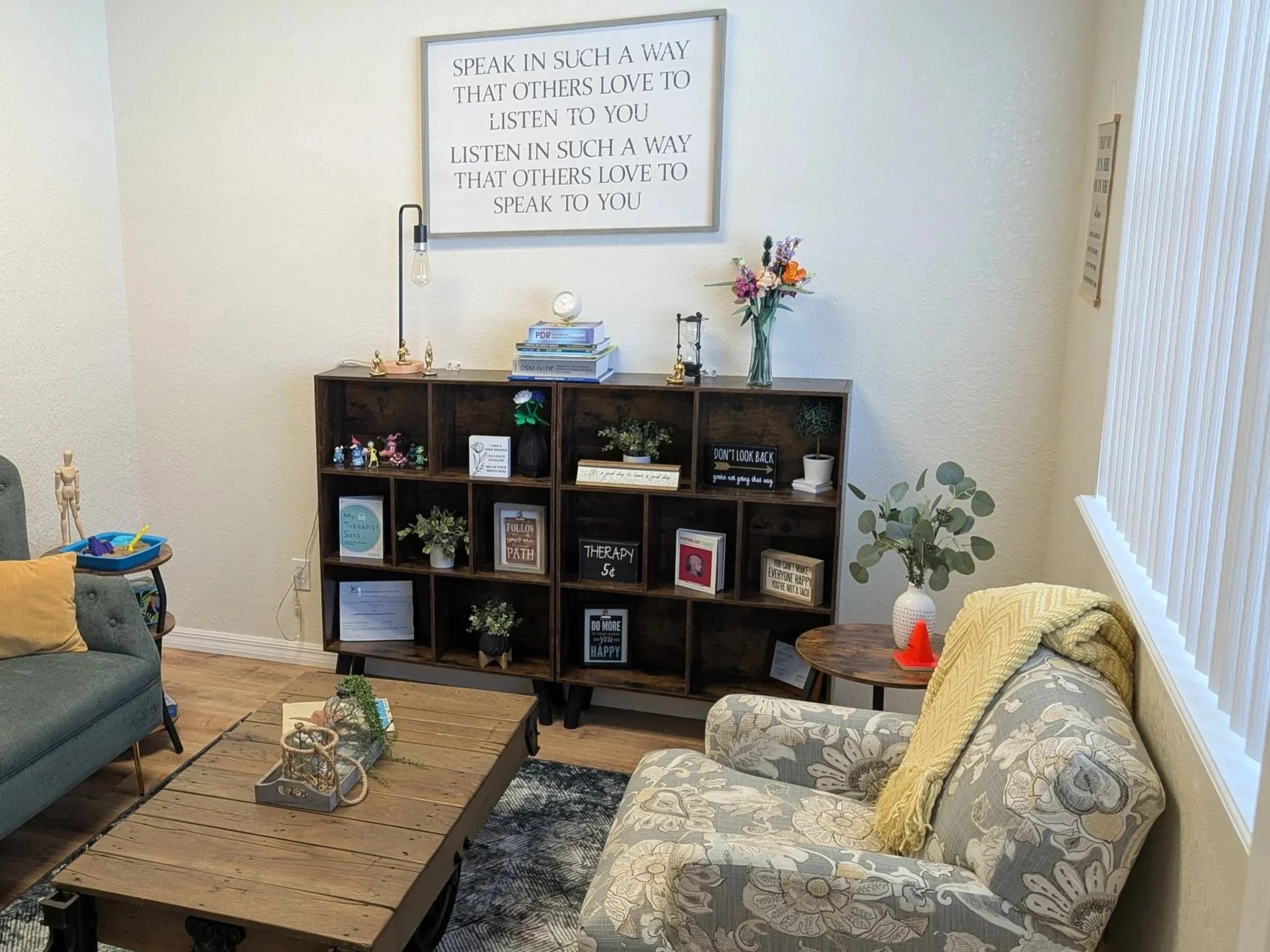 Cozy and bright mental health counseling office with comfortable seating and a wood bookshelf in Titusville, Space Coast.