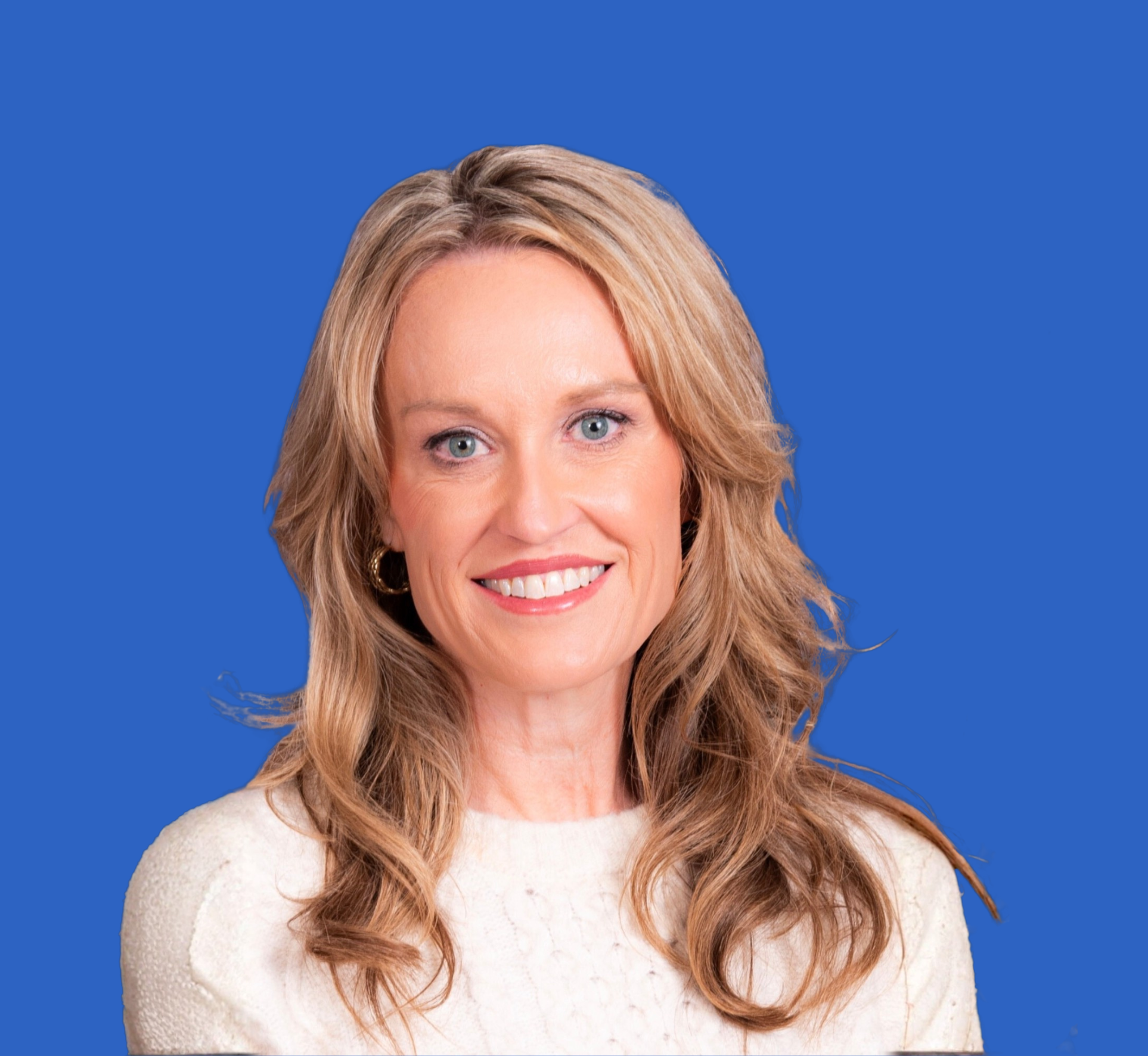 Portrait of a smiling woman with blonde hair, wearing a white sweater, who is a fiv fs fundraising coach.