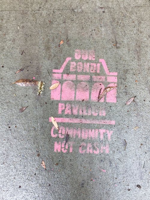 'Community Not Cash' Signs