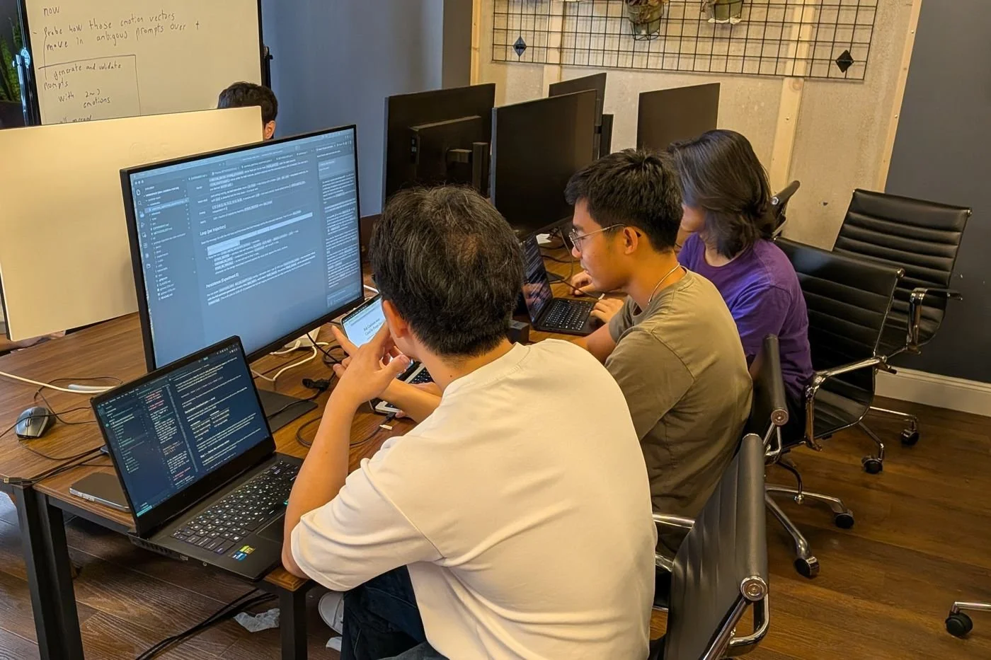 Participants working at a row of desks with monitors