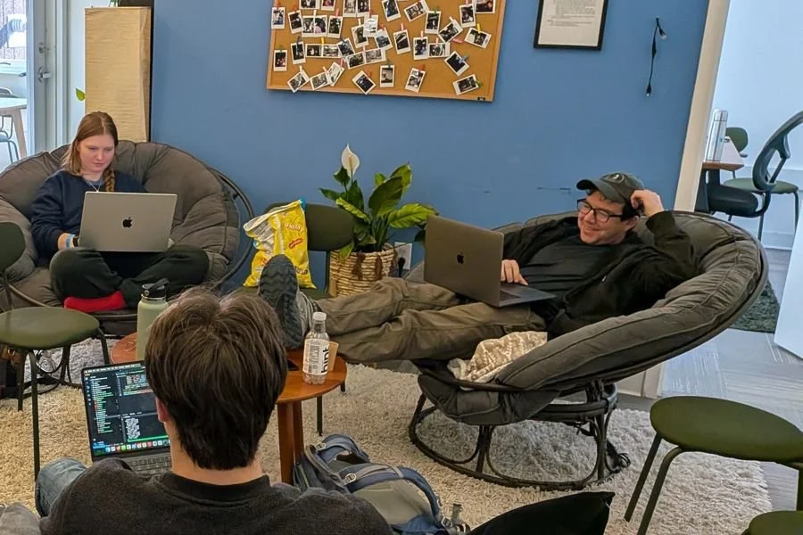 Participants working on laptops in the office lounge