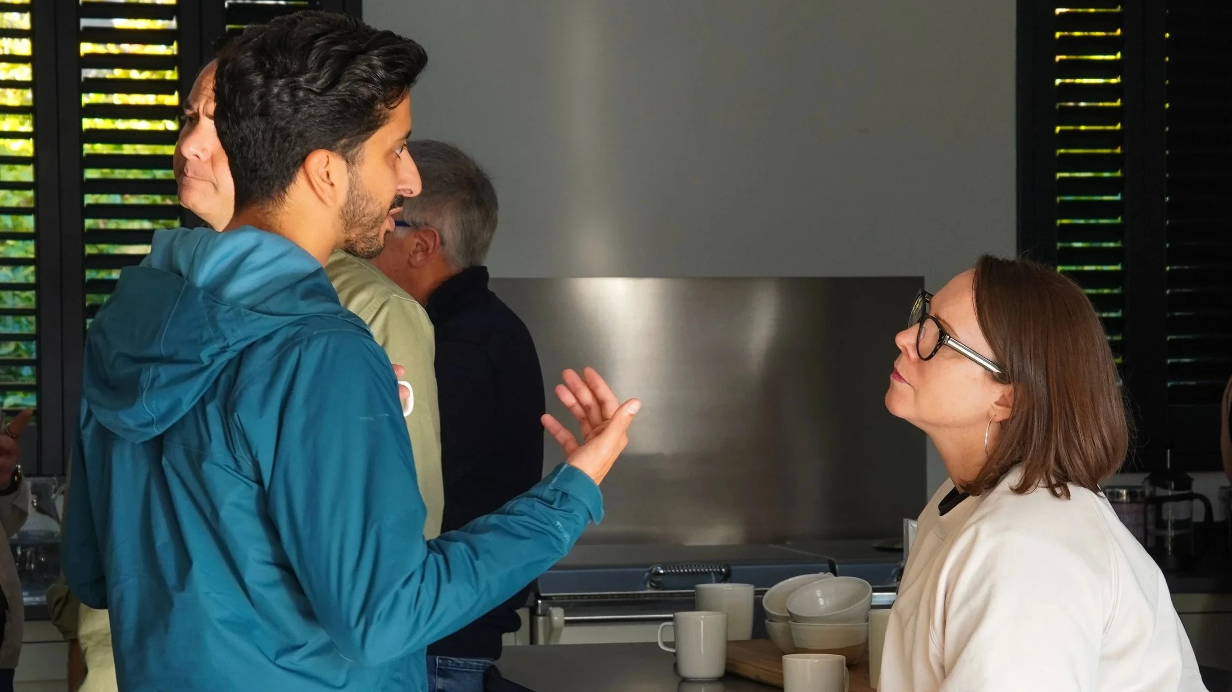 group of leaders in conversation outdoors, taking part in a team coaching day with Collaboration Equation to build trust and improve how they work together.