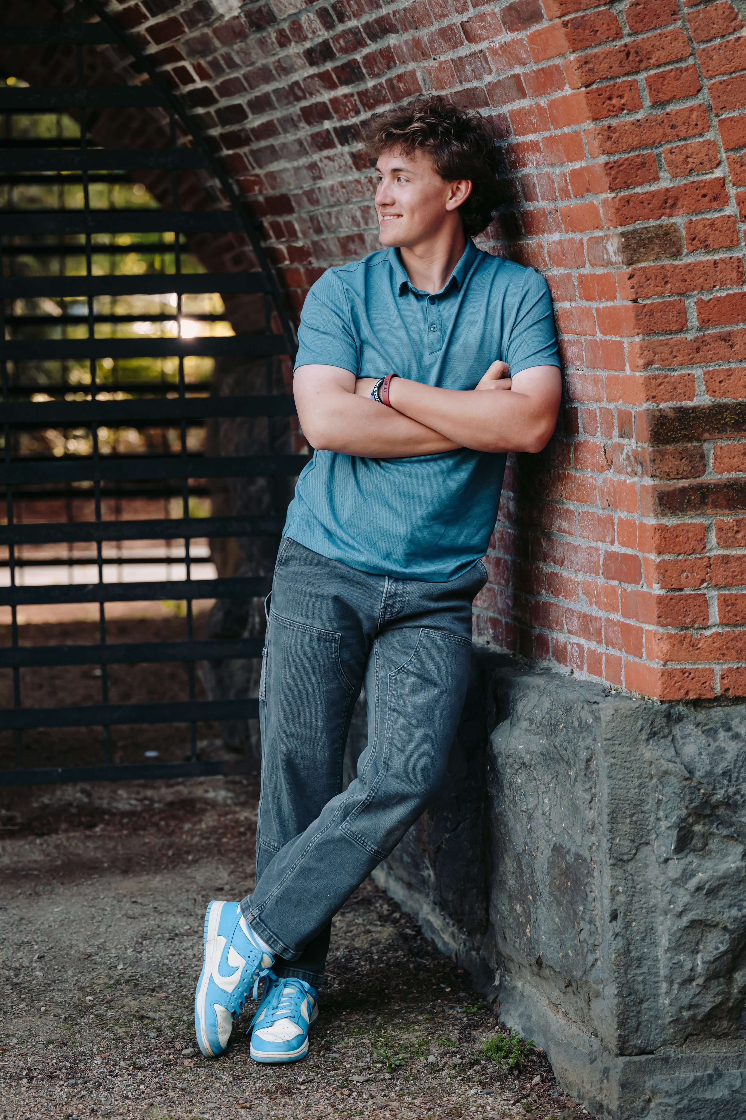 Senior guy leaning against brick wall