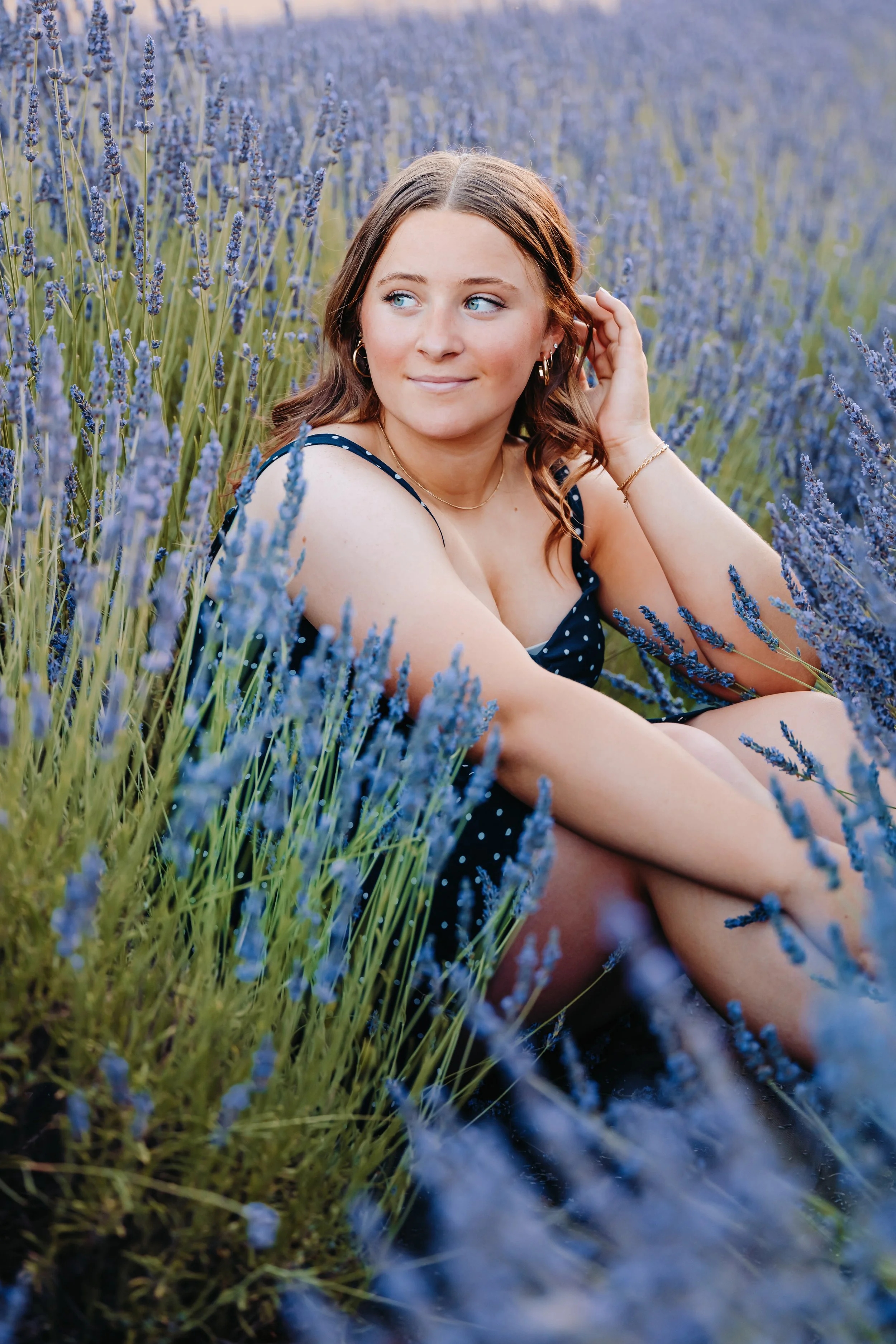 Girl sitting in a bed of lavender for senior photos