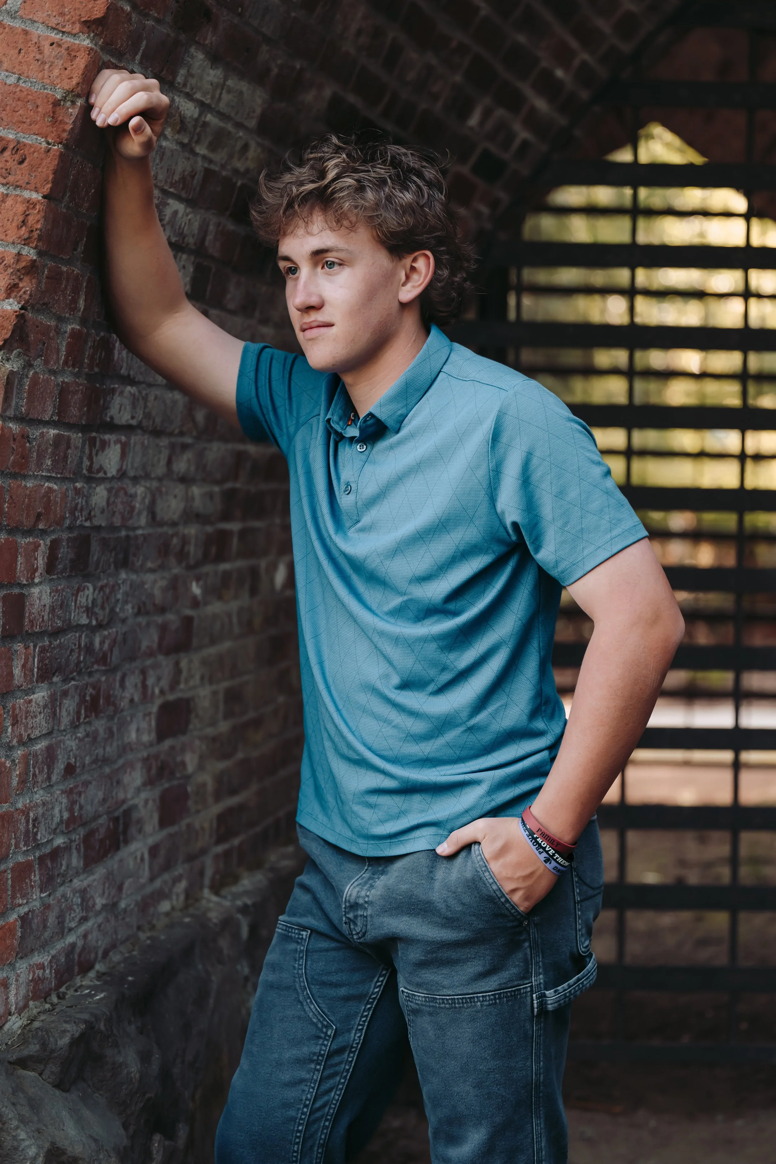 Senior guy at photoshoot leaning on wall at George Rodgers Park in Lake Oswego, Oregon
