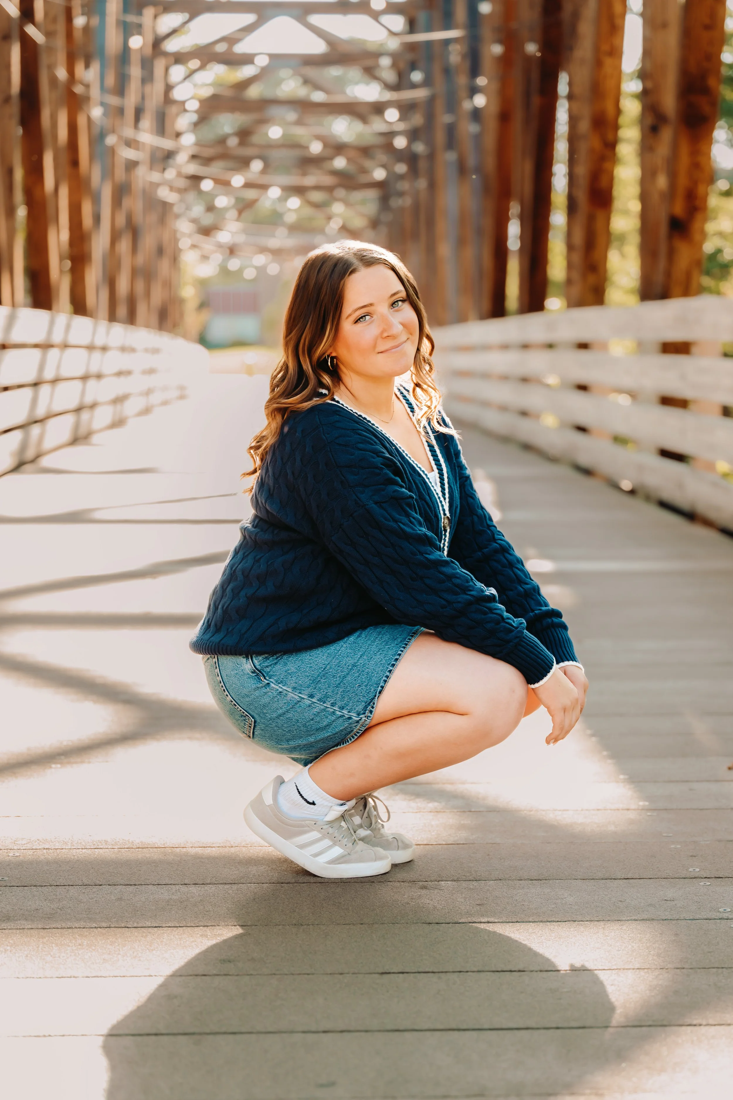 Senior girl squatting sown and smiling for photo