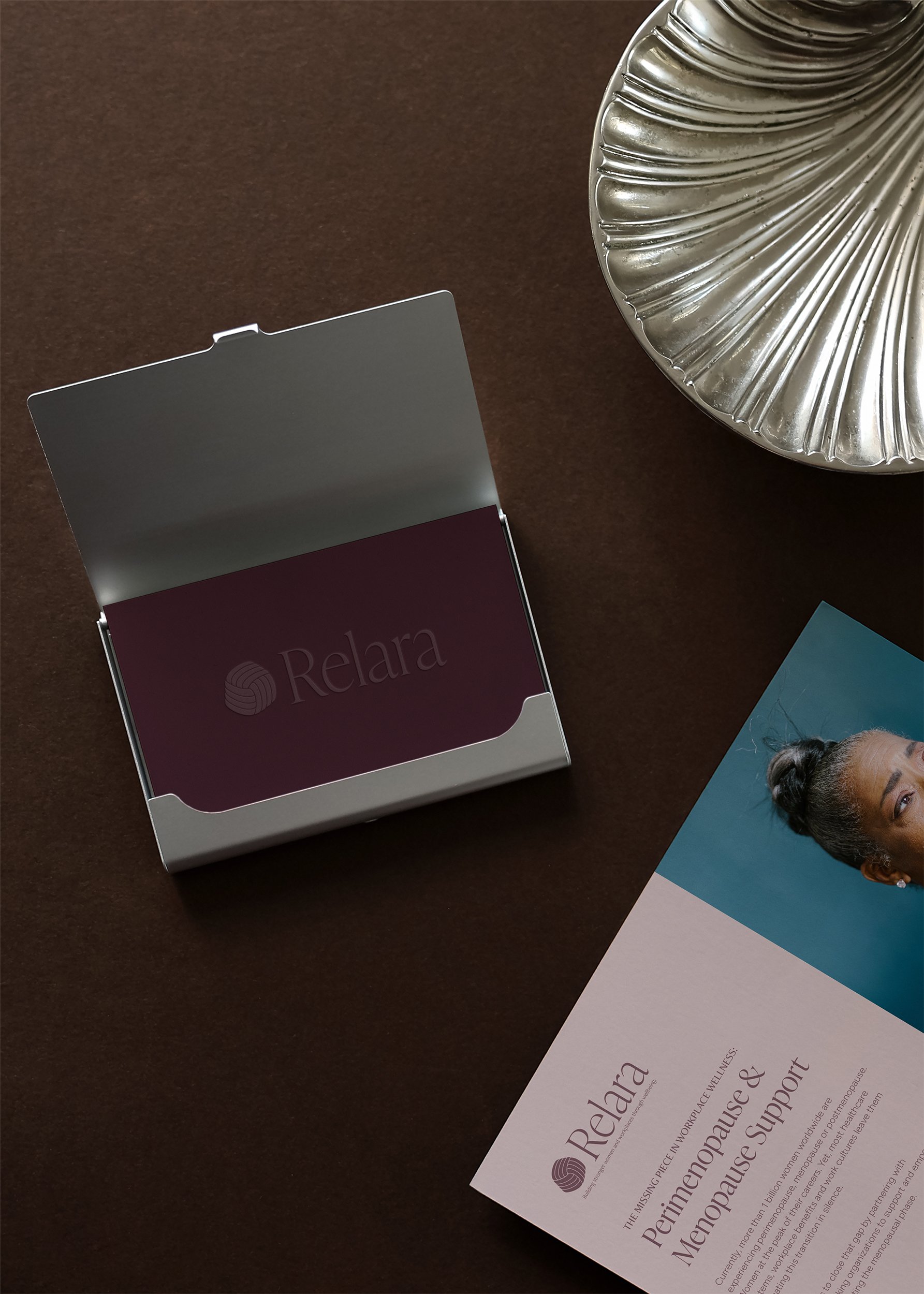 Mockup of a business card and an A6 card with Relara's logo, as well as content set in Relara's brand typography and colors.