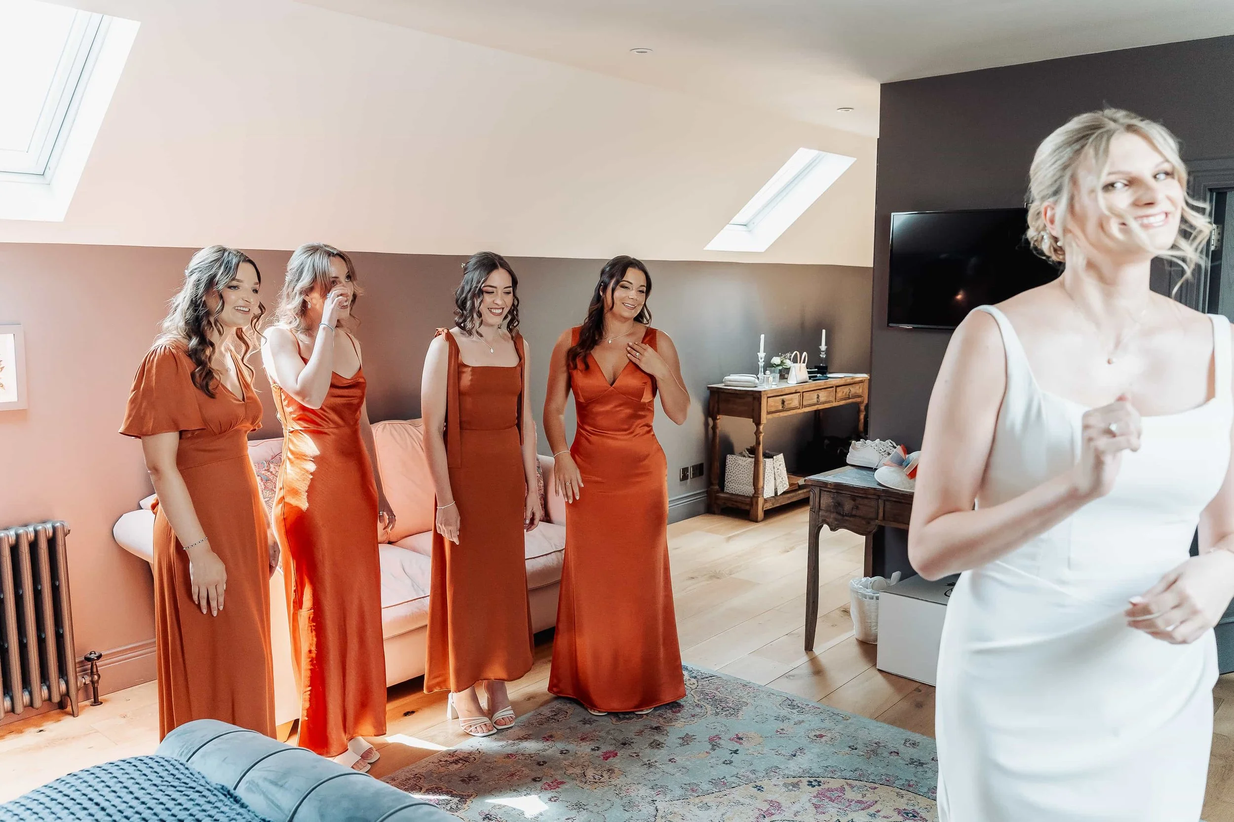 Bridesmaids reacting emotionally to seeing the bride in her wedding dress for the first time