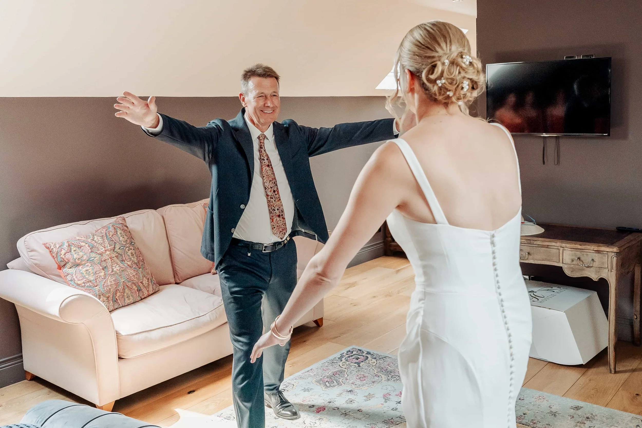 Father of the bride with arms open, seeing his daughter in her wedding dress