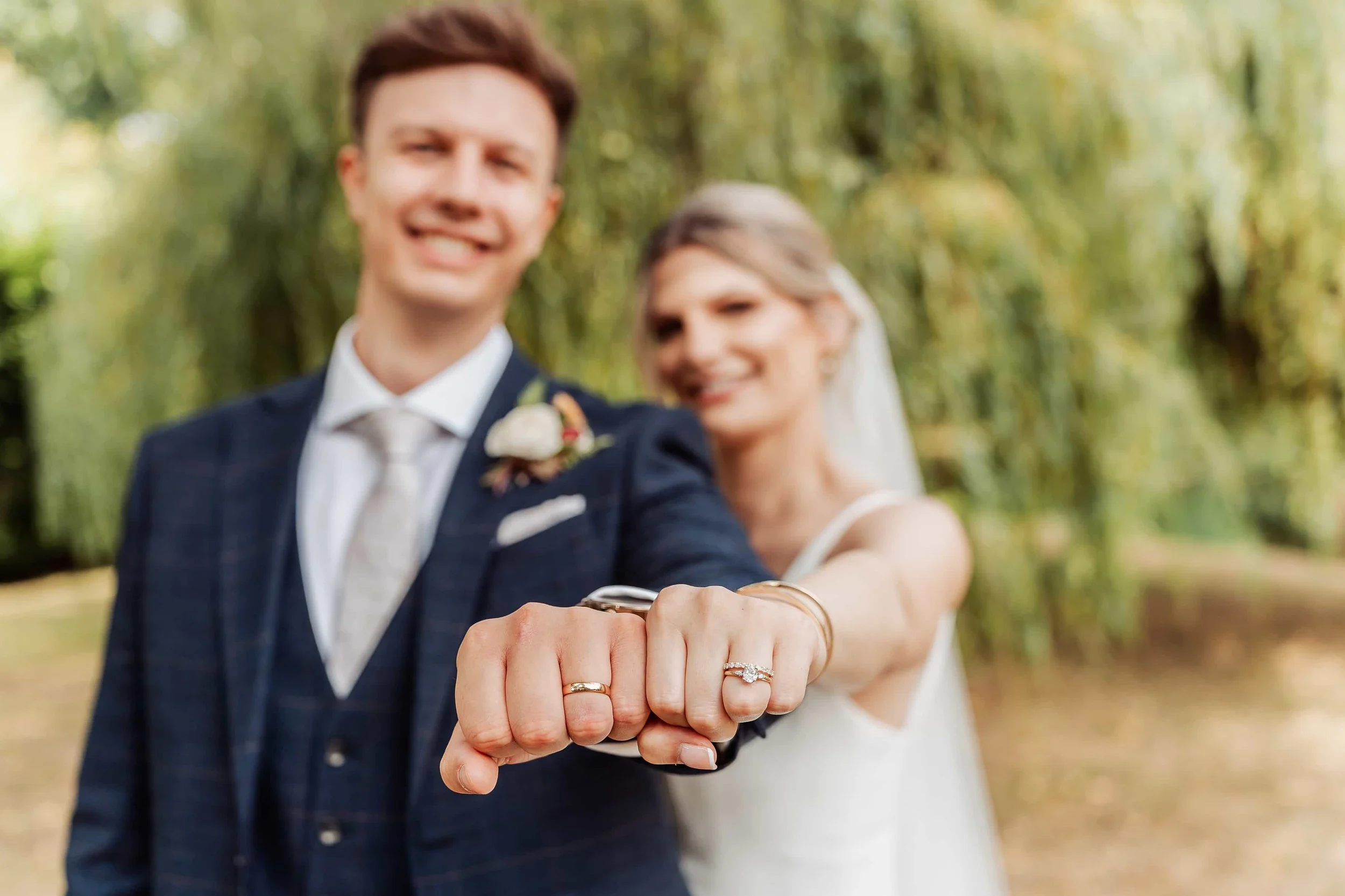 bride and groom with the hands outstretched showing the new wedding rings