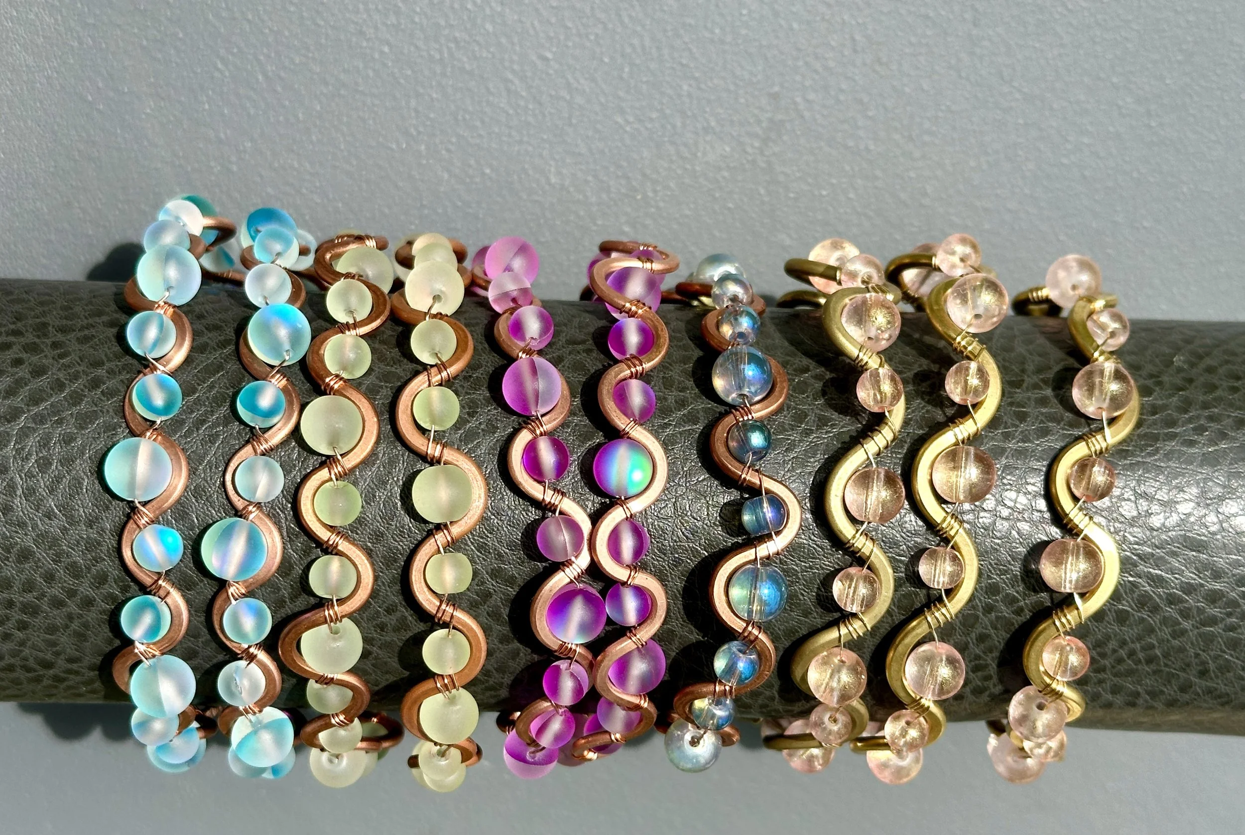 copper and brass squiggly bracelets with colorful glass beads