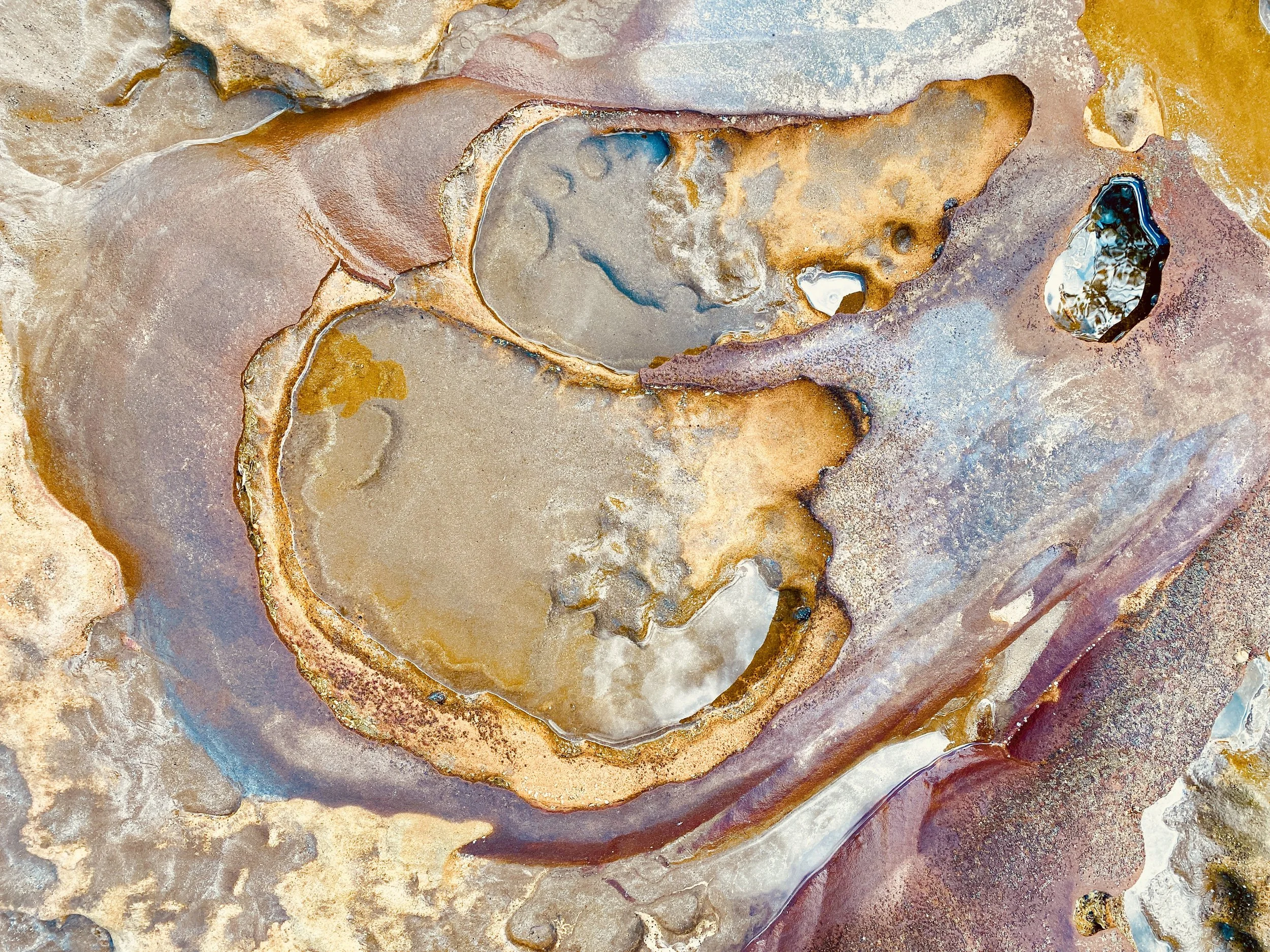 water pools on calming pink and golden rocks