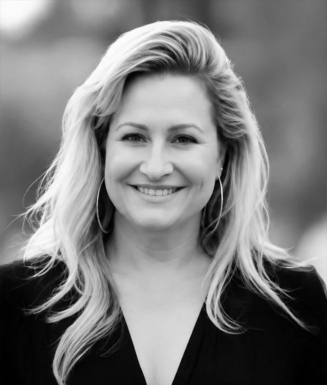 Black and white photo of a woman with long hair smiling outdoors