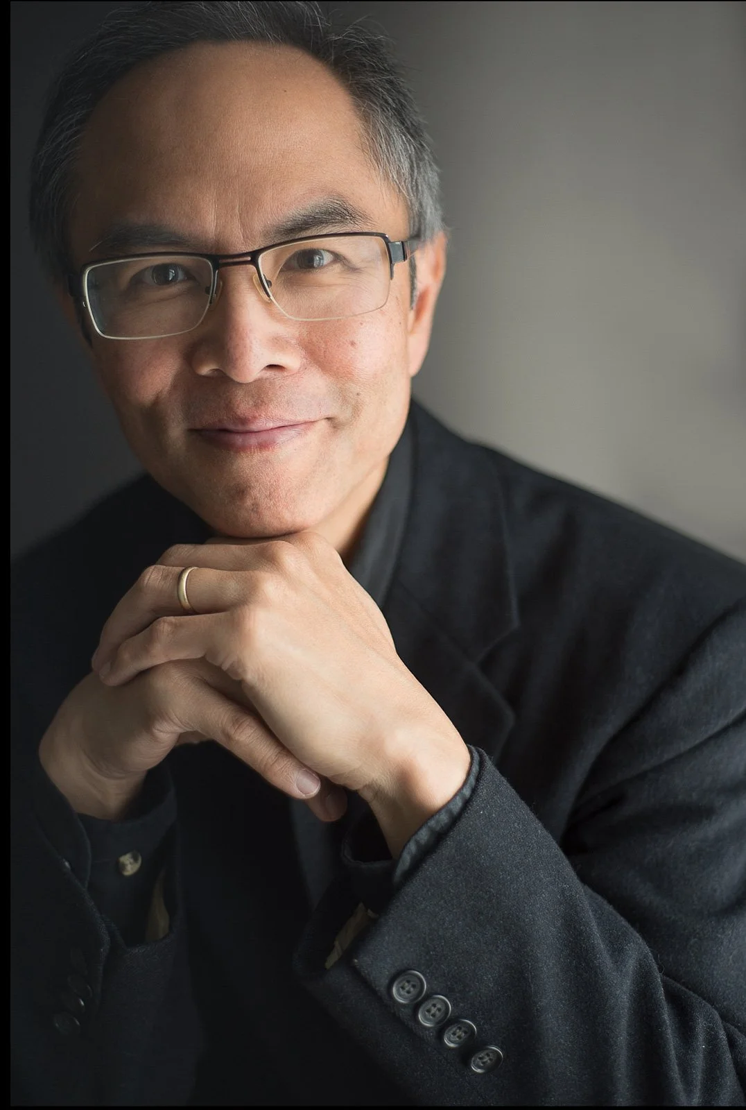 contemplative man in glasses wearing a black suit for his author portrait photography session.