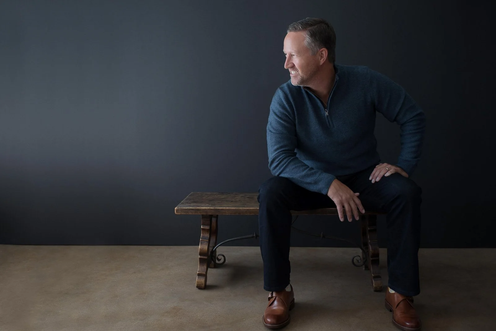 casual business man sits on bench looking towards left