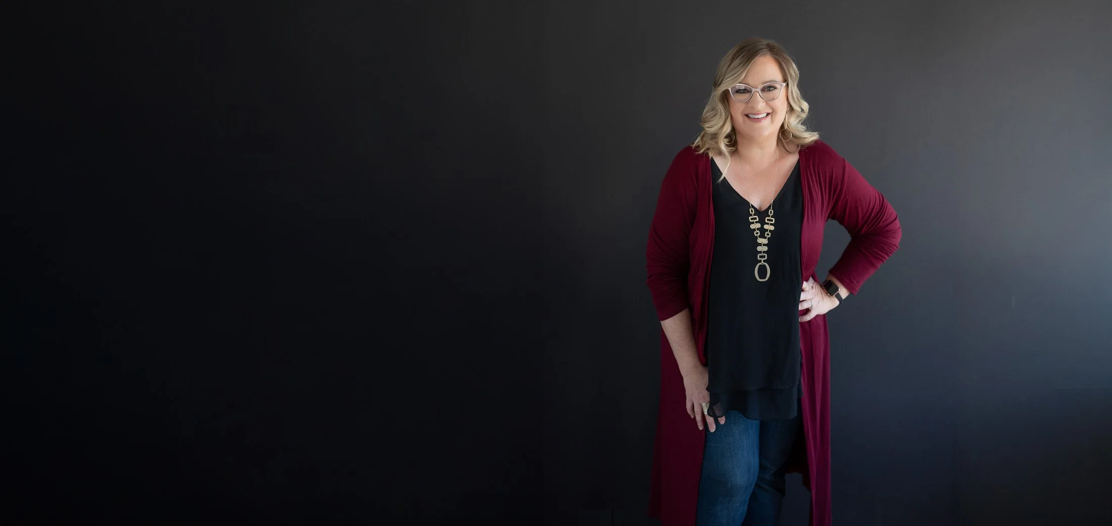 Blonde woman in glasses poses looking at the camera Stephanie Simpson owner of BRAND-ification