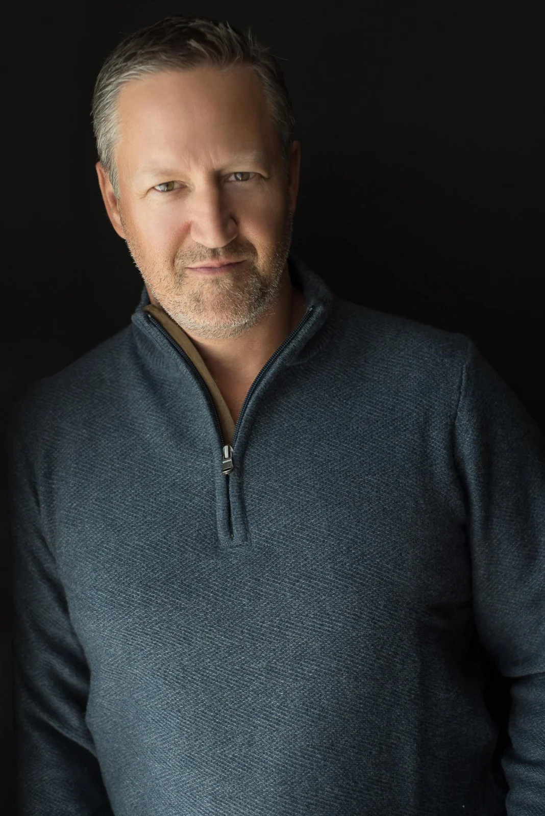 Dramatic studio headshot of male executive against dark background — editorial headshot photographer LA