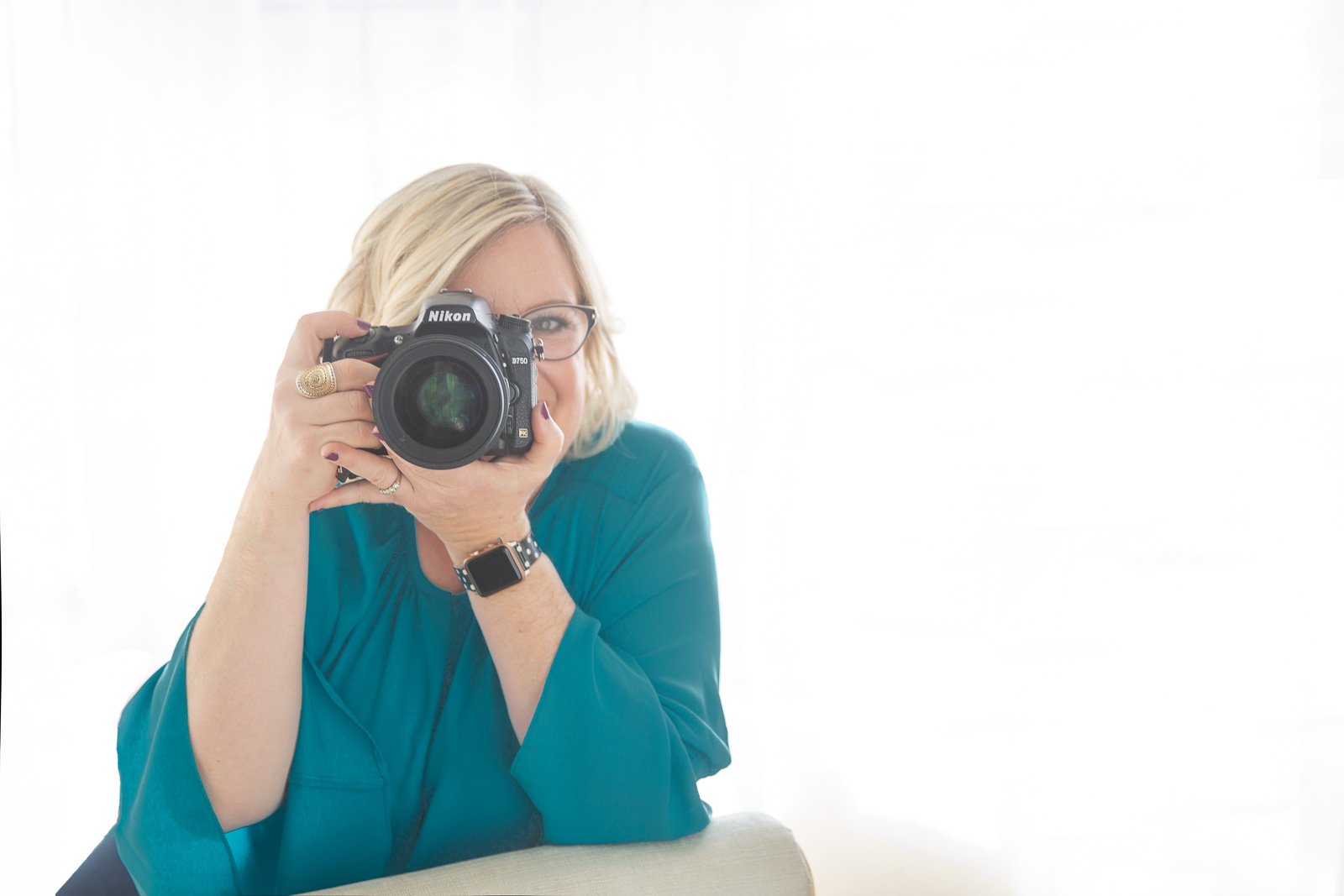 Female photographer Stephanie Simpson in blue point camera at the camera.