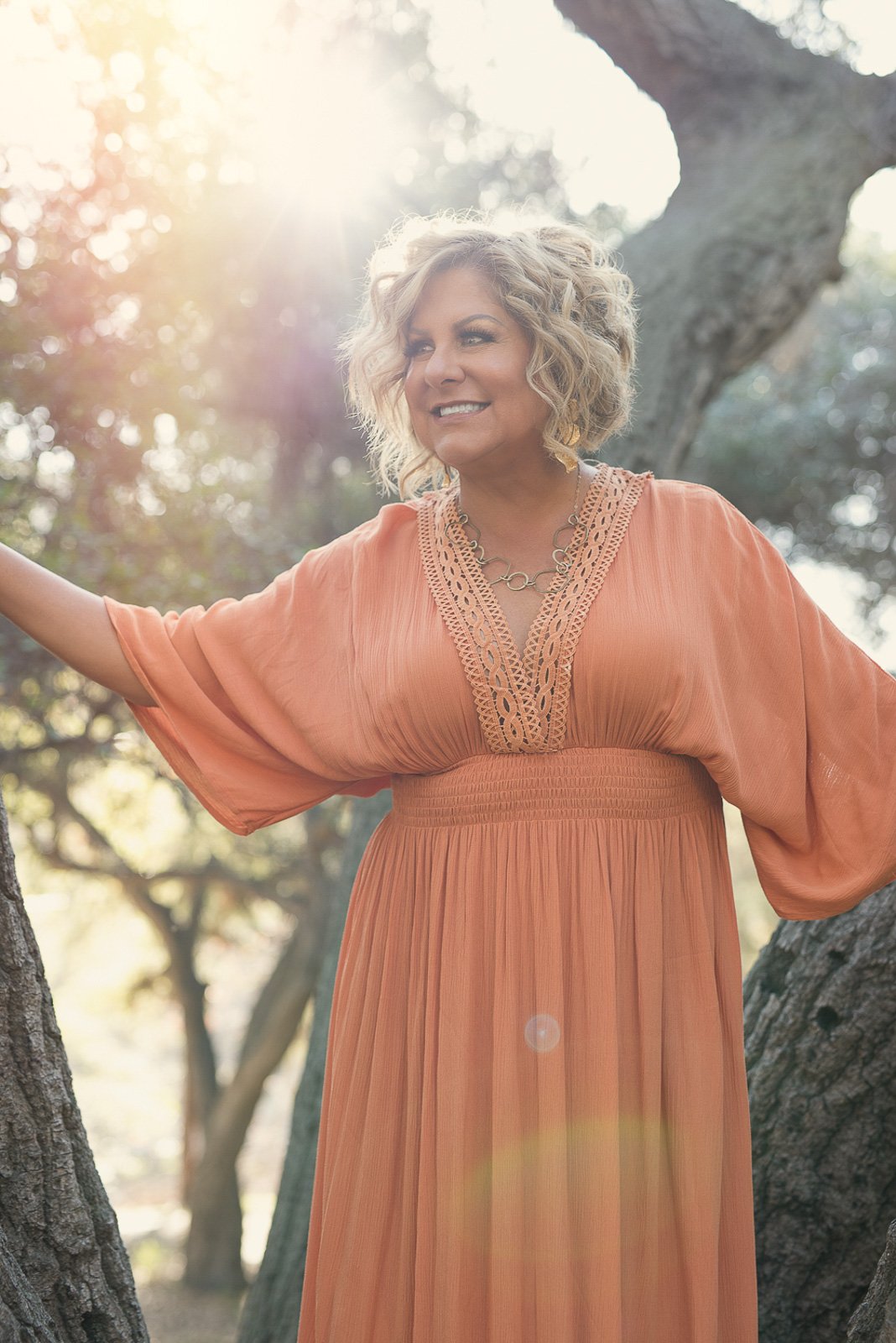 Creative wellness entrepreneur in flowing dress photographed outdoors in golden natural light branding session.