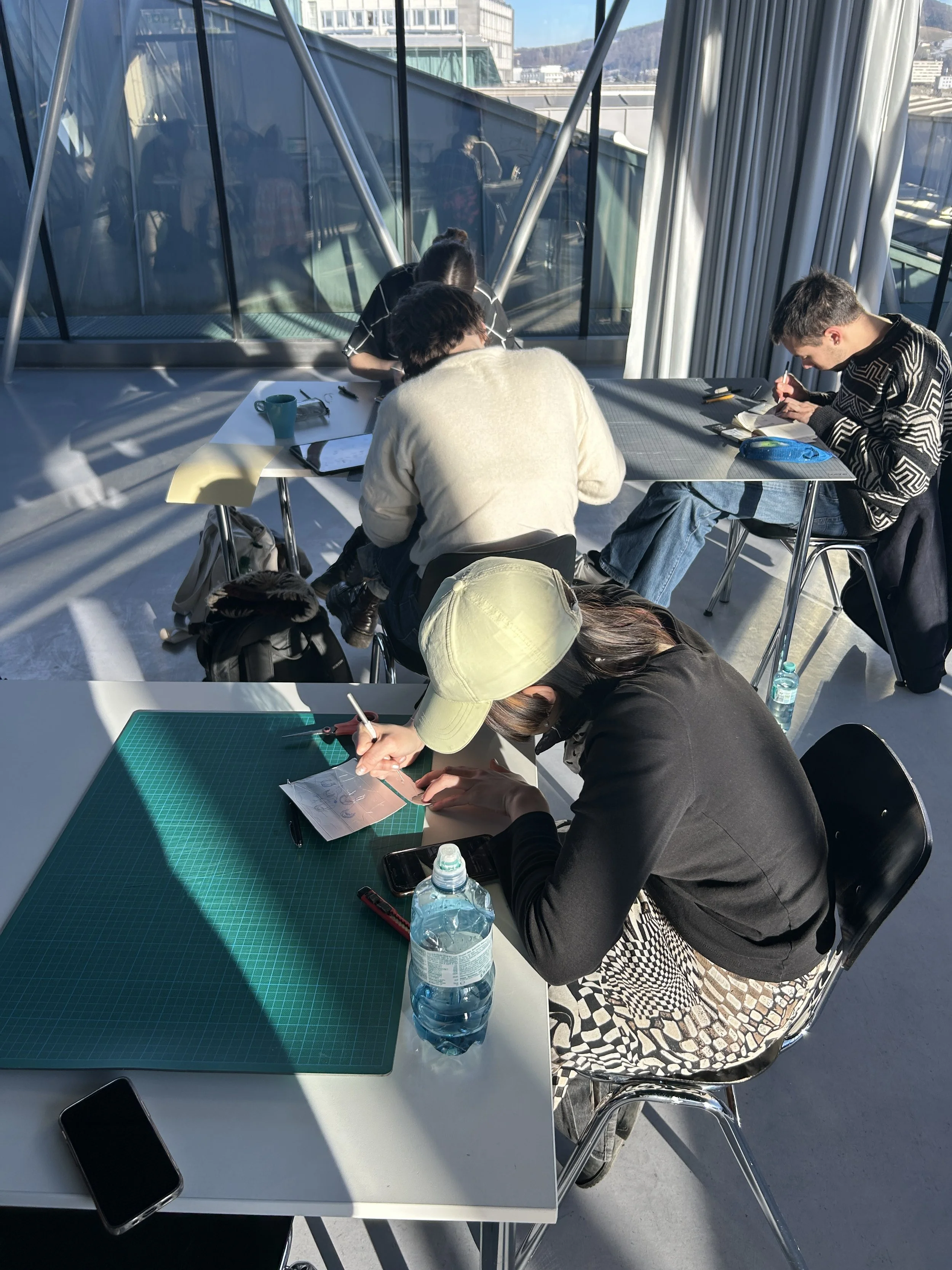 Four people sitting at a desk scratch their image on to Tetrapacks.