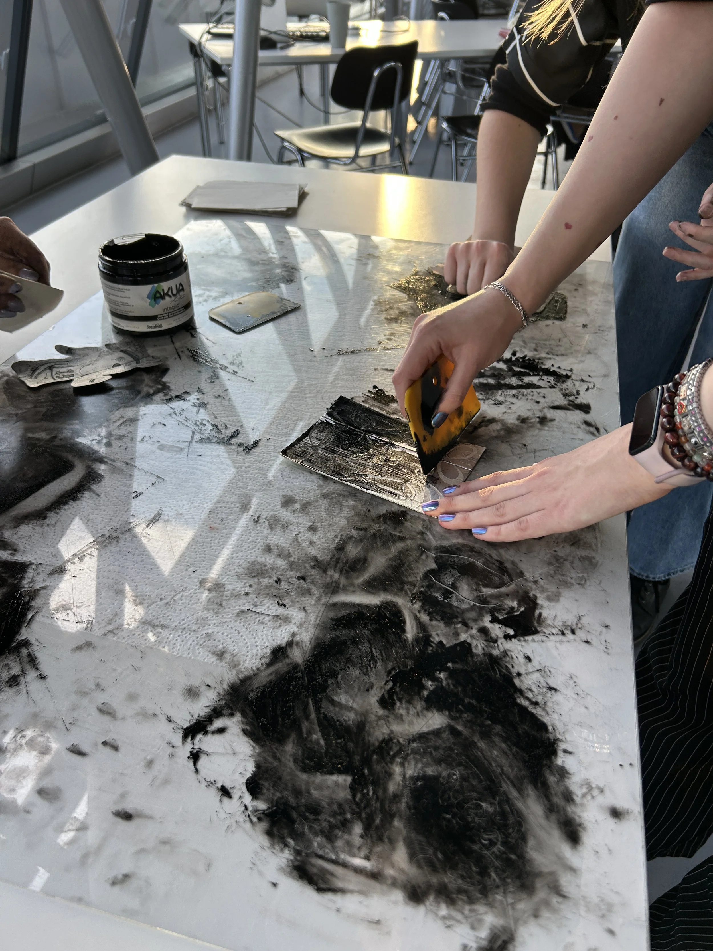 A person spreads black ink on their Tetrapack printing plate.