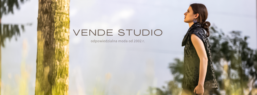 A woman stands outdoors near a tree, facing to the right, with a river and trees in the background. The image includes the text 'Vende Studio' and some smaller text below.