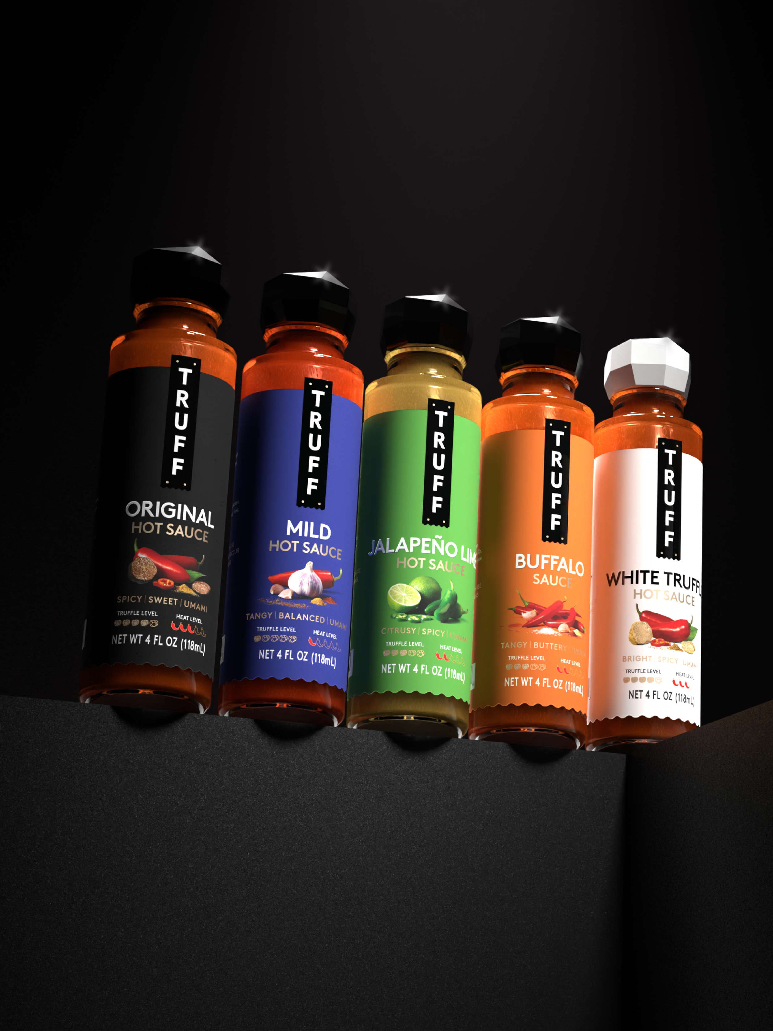 Five bottles of Truff hot sauce with different flavors, including Original, Mild, Jalapeño Lime, Buffalo, and White Truffle, arranged in a row on a dark surface.