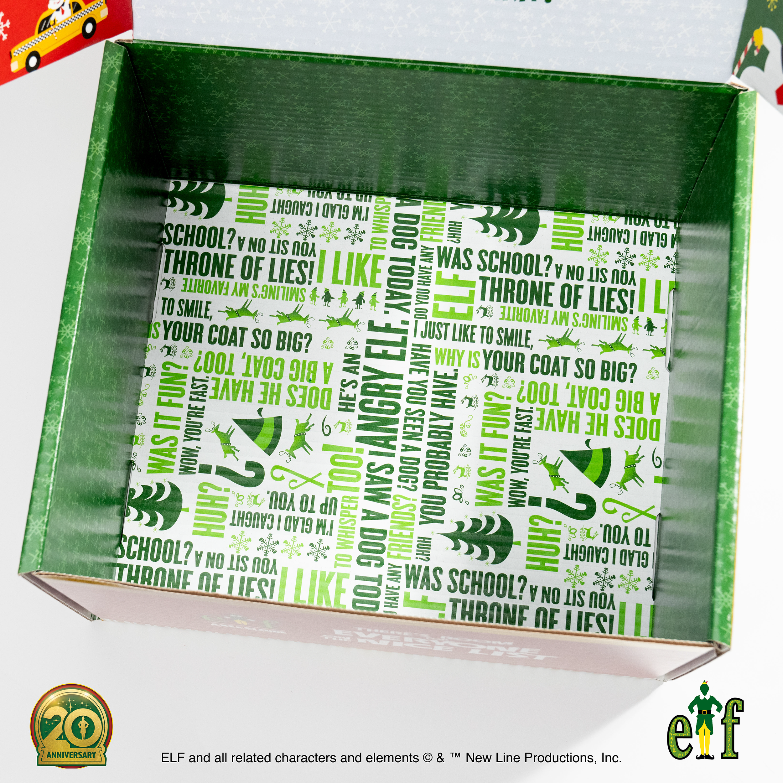 Empty Christmas-themed cardboard box with green and white printed interior and holiday designs, logos, and messages.