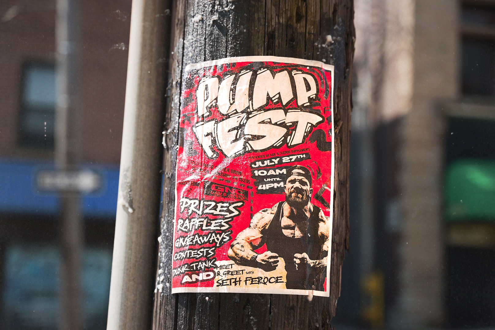 Red and black flyer for a punk festival called 'Punk Fest' on July 27th from 10 AM to 4 PM, featuring a photo of Seth Ferose, with details about prizes, raffles, and contests, attached to a wooden utility pole.