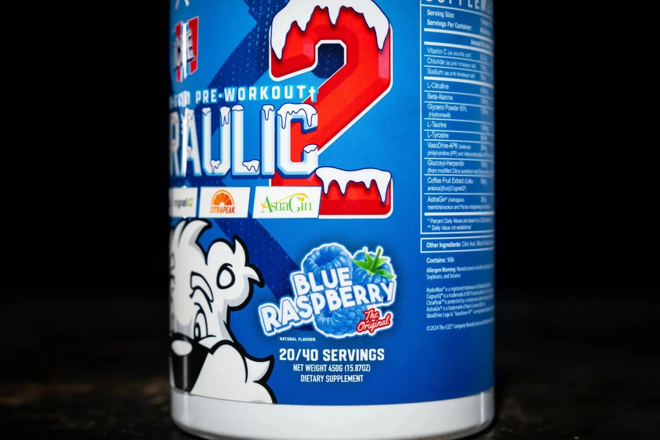 A container of powdered Blue Raspberry flavored energy pre-workout supplement titled "Celsius 2.0" with branding indicating it contains ingredients like citrulline, AstraGin, and beta-alanine, and features a cartoon mascot.