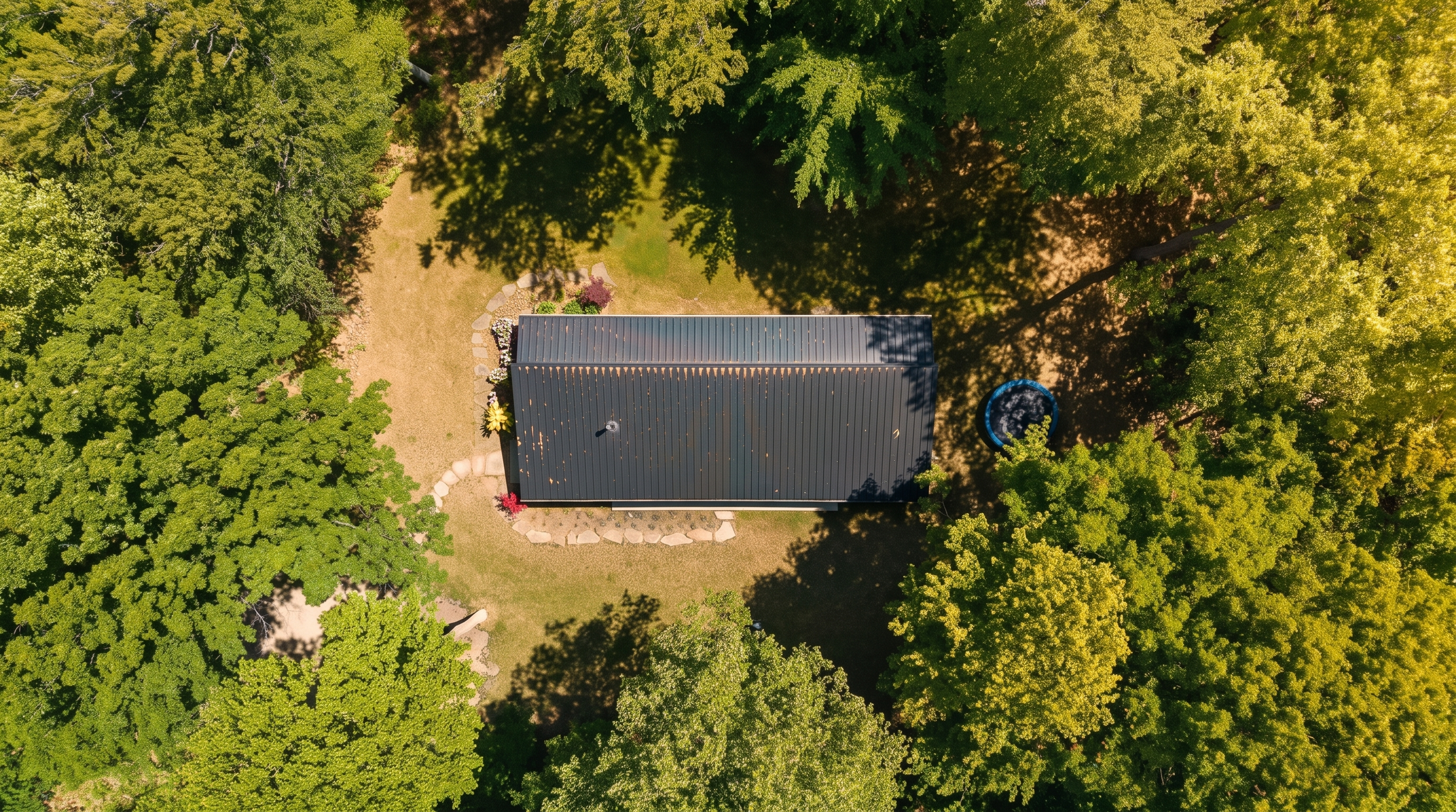 Aerial view of Lake Effect Cabin's black roof surrounded by its private woods