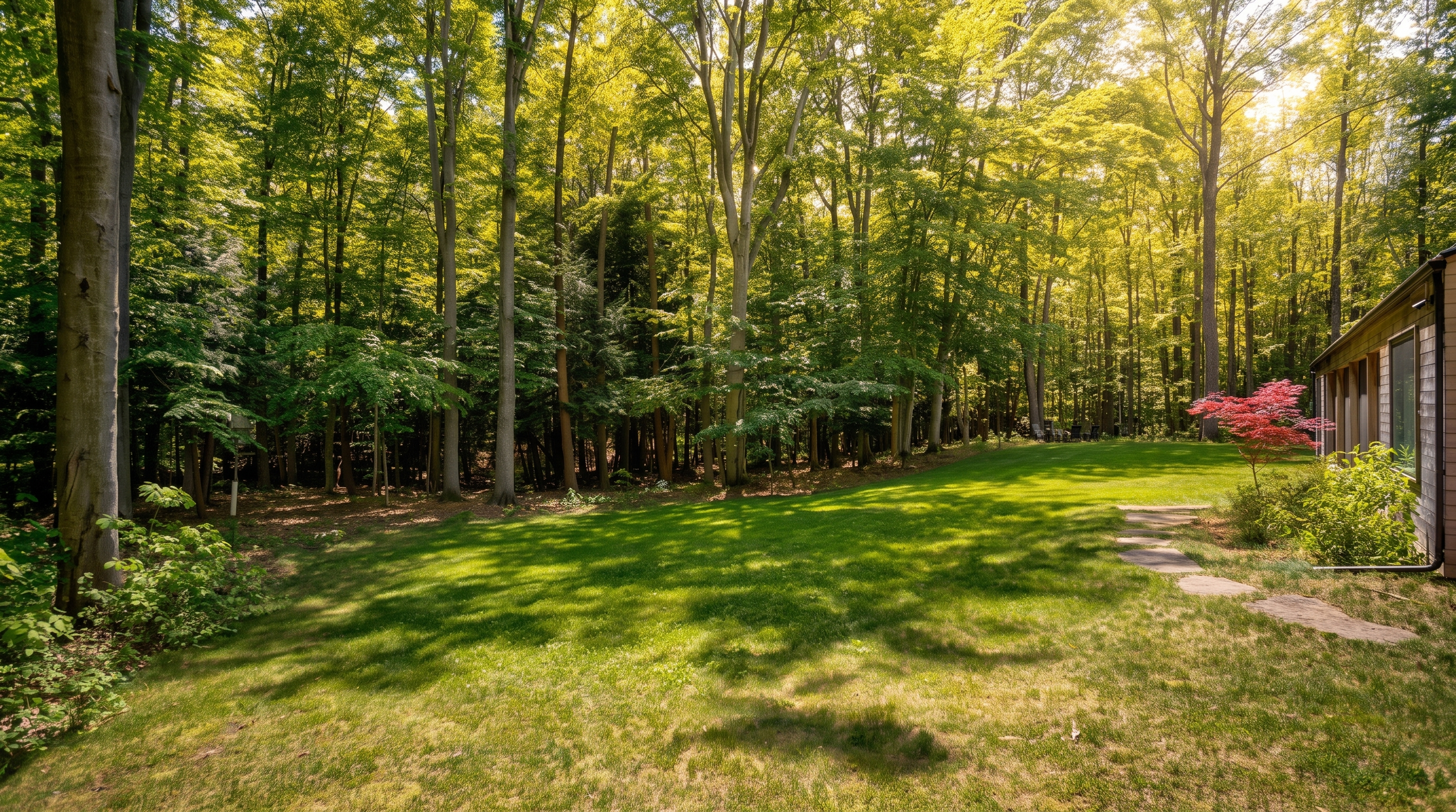 Grassy yard and stone path along the side of Lake Effect Cabin