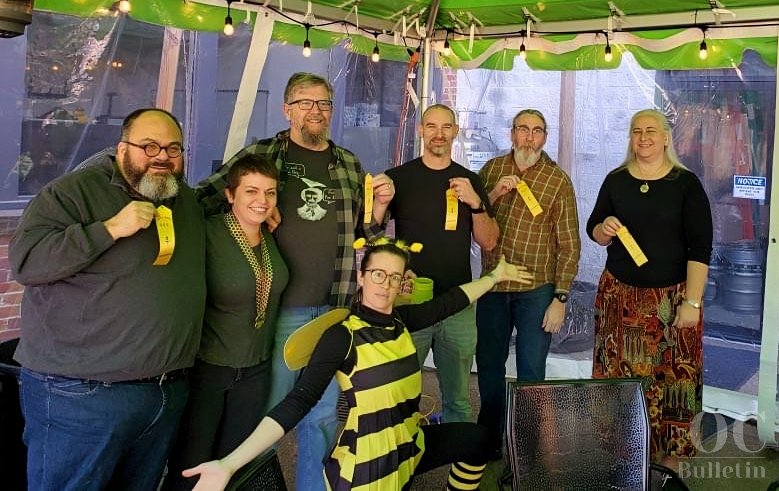  Adult spelling bee contestants with emcee Jess Cifizzari. (Hint: If you look closely, you might see confirmation that a certain OC Bulletin editor can, in fact, spell.) (Photo Credit: Cindy Pagan) 