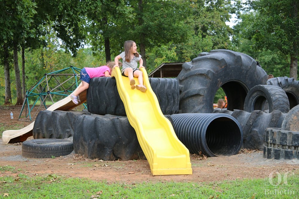  A young girl chats with her dad before going down the slide at Community Give Back Day on Sept. 30. (Photo Credit: Andra Landi) 