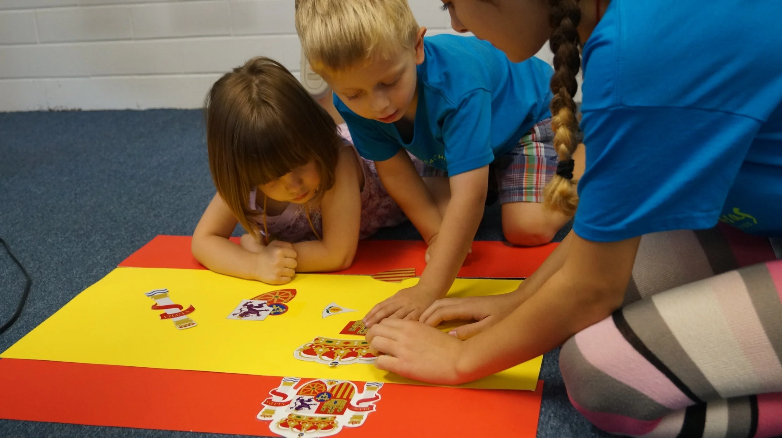 Camp counselor  helping students build the flag of Spain