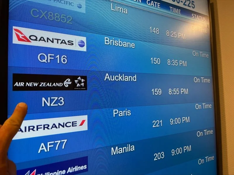 Airport departure board showing the details of an AirNZ flight to Auckland NZ