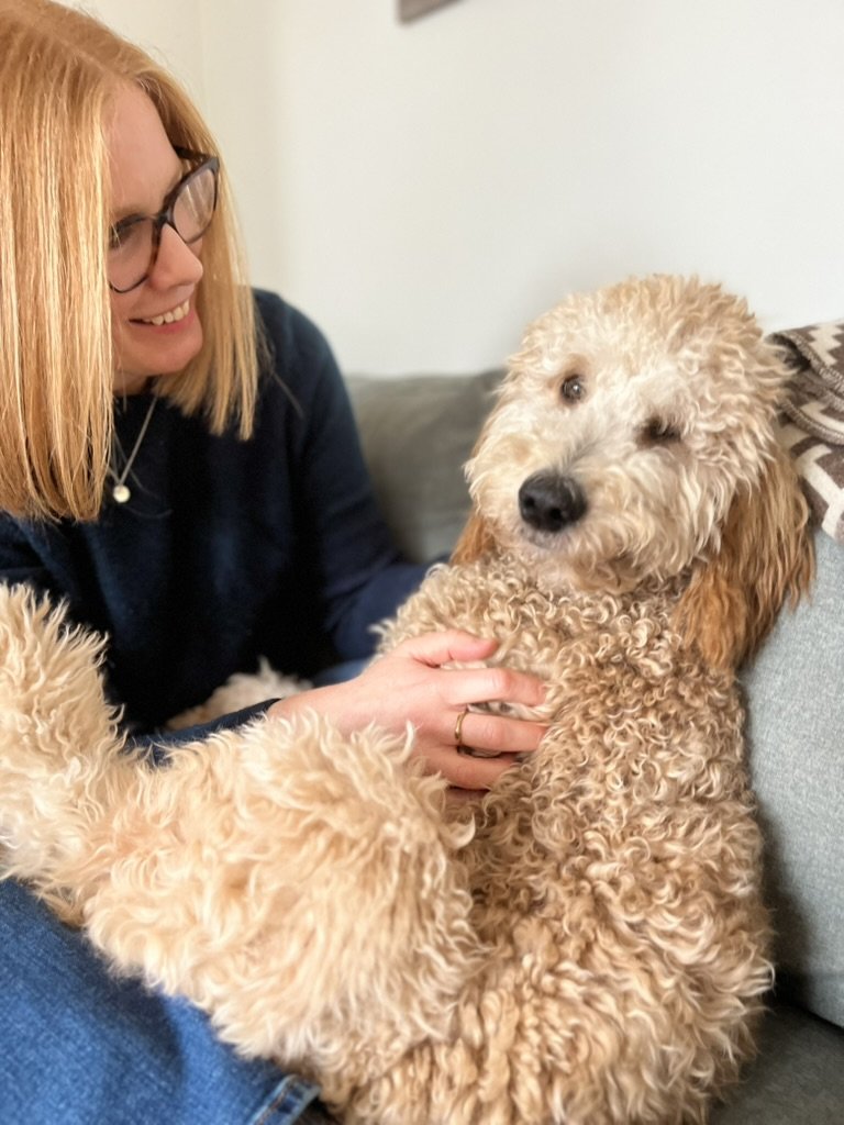 Robyn Kozak, perinatal therapist in Burnaby BC, wearing glasses petting her therapy dog.