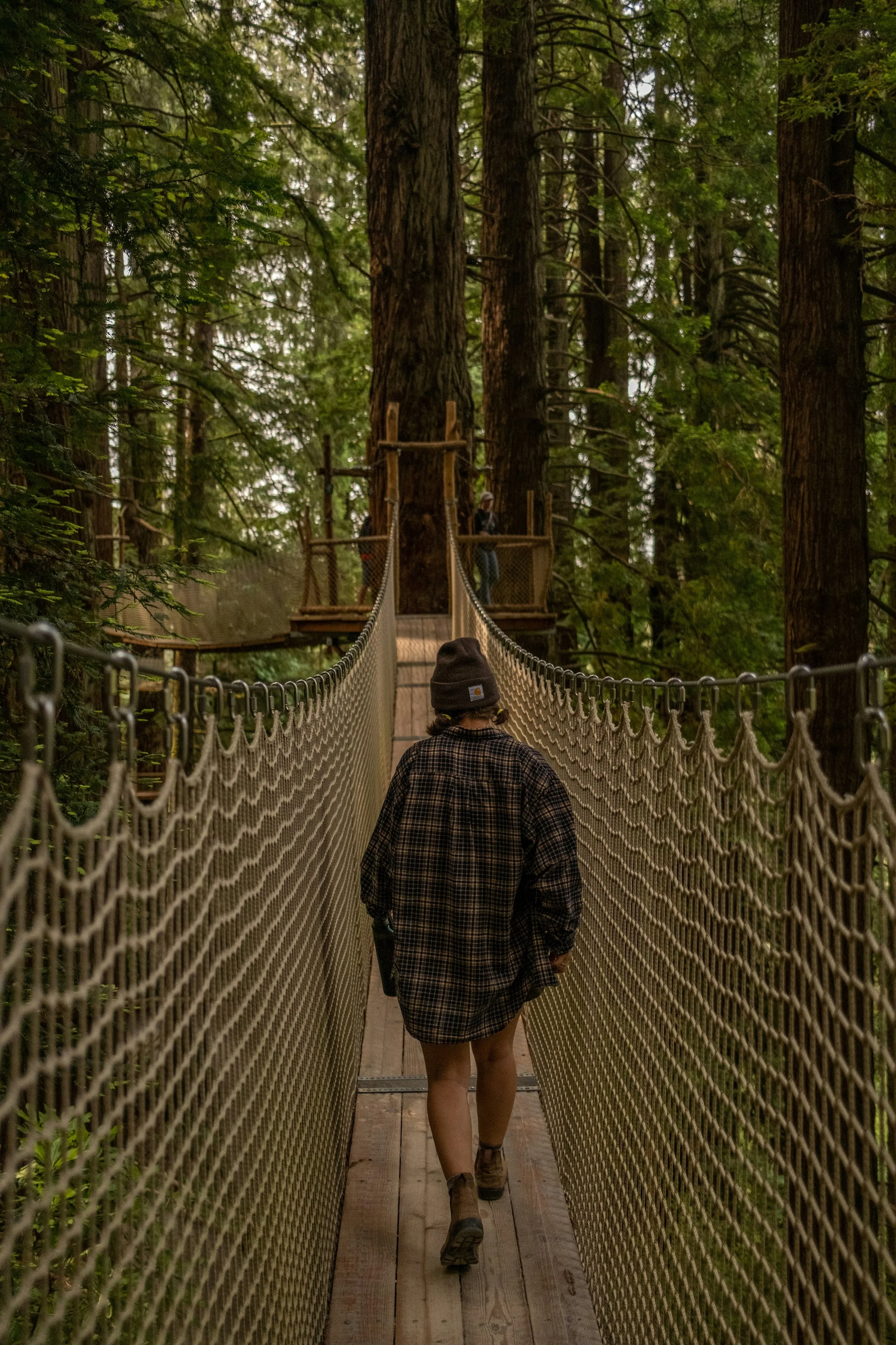 A female walking on a Burnaby BC rope bridge, thinking about trauma therapy and perinatal counselling.
