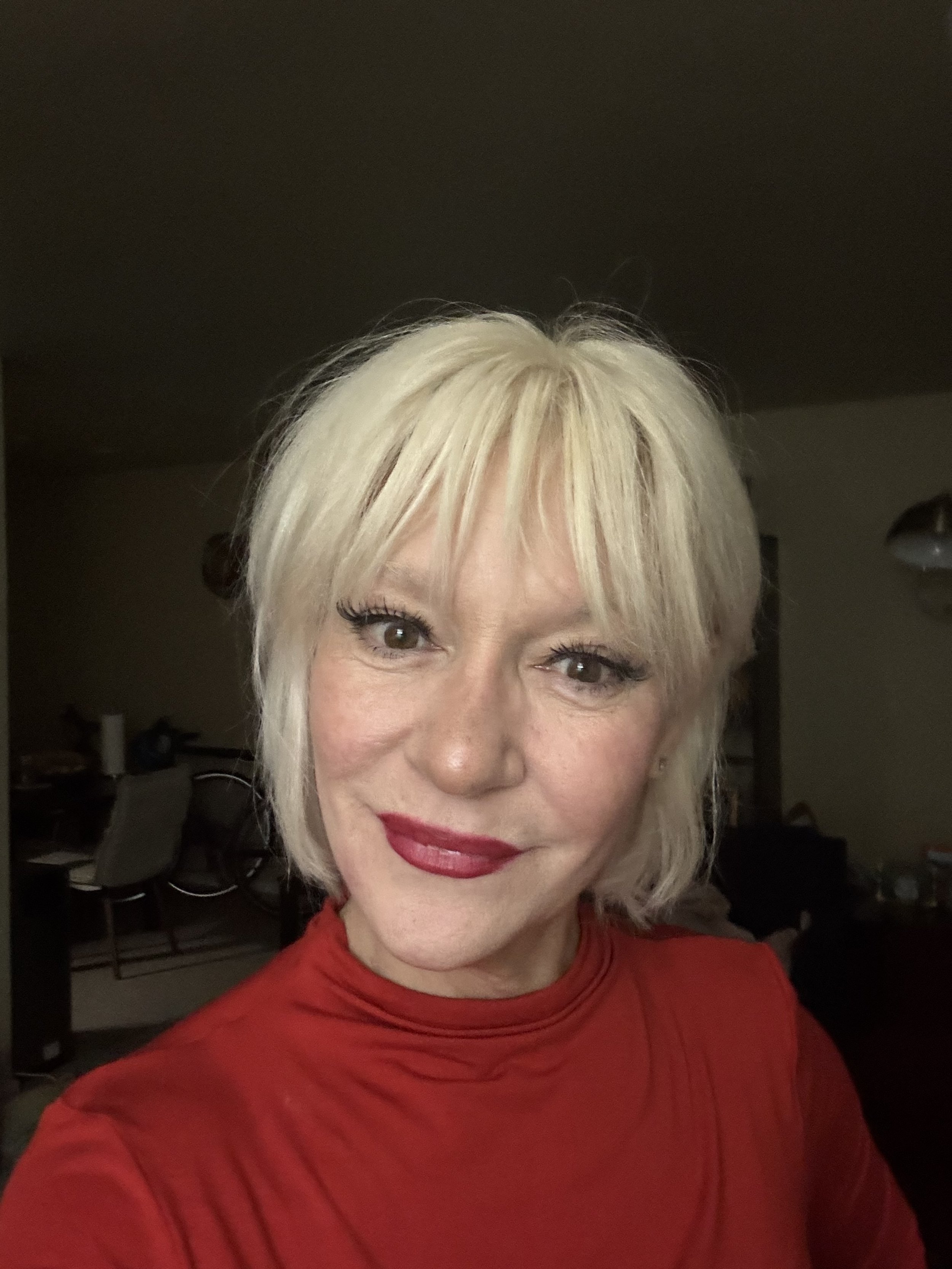 women with short bleach blonde hair with red lipstick and red shirt