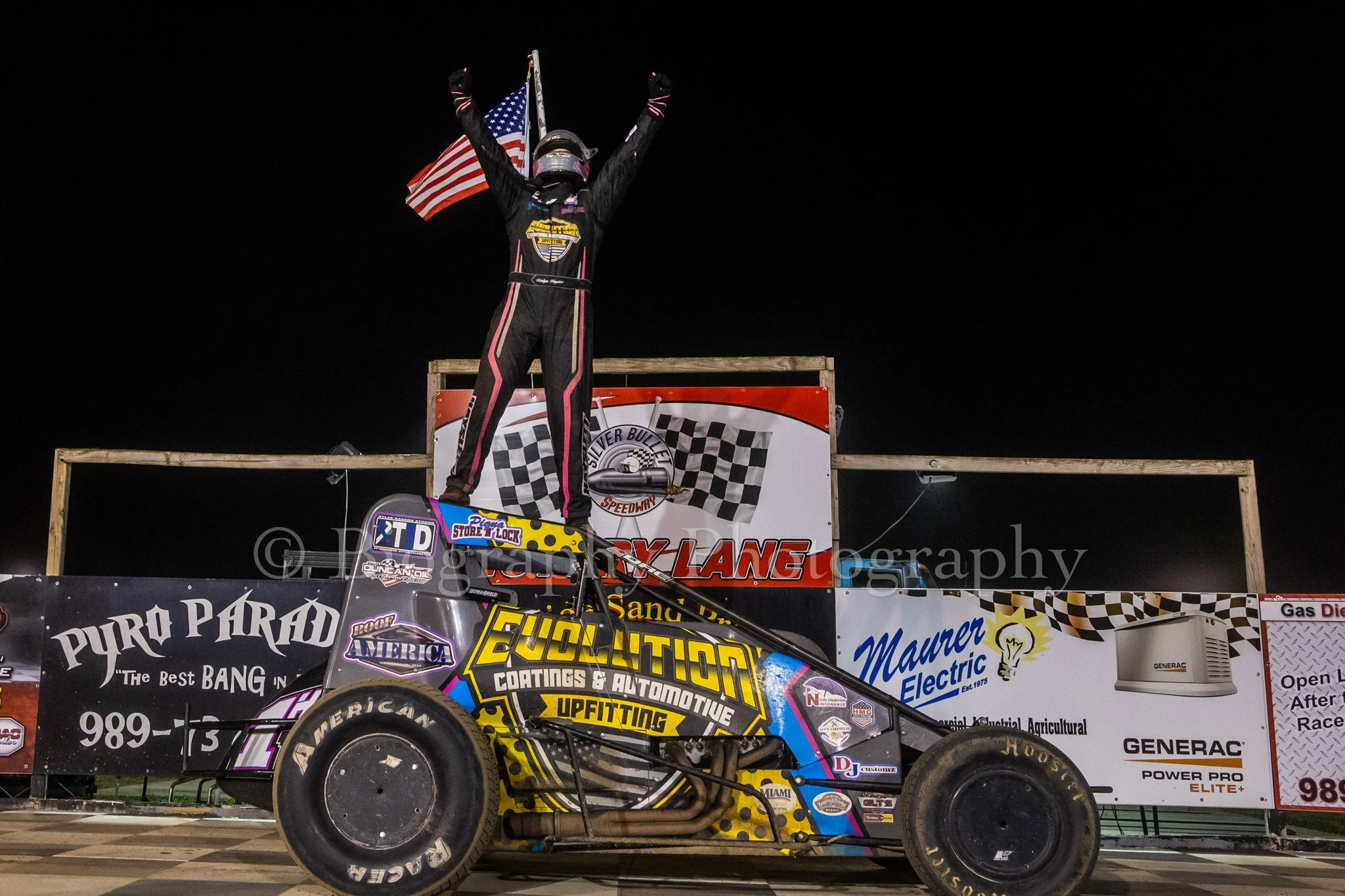 Sprint Car in victory lane at a dirt track stand on top of his car celebrating in Michigan at Silver Bullet Speedway