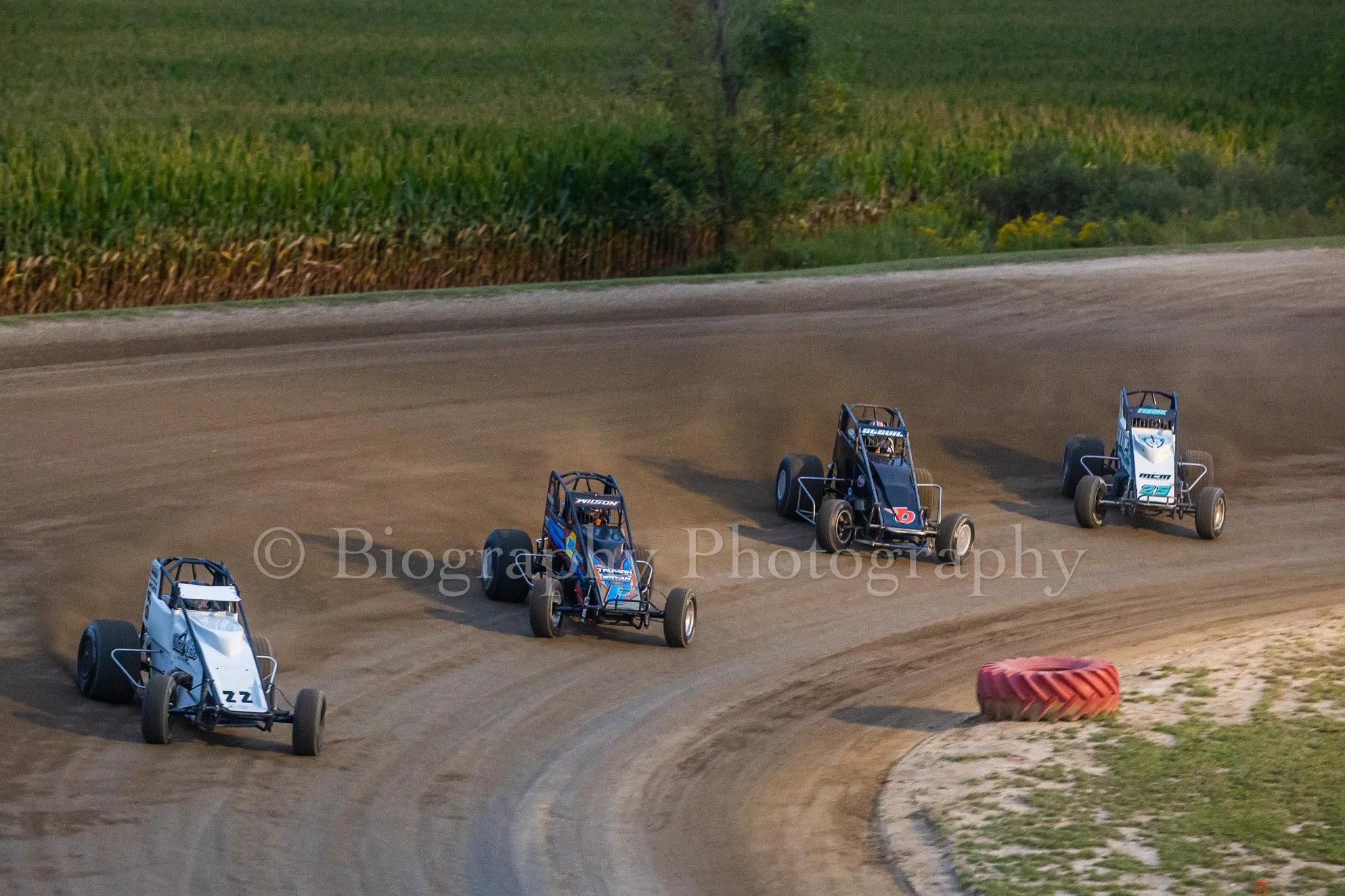 Sprint cars going around a dirt track corner at Silver Bullet Speedway