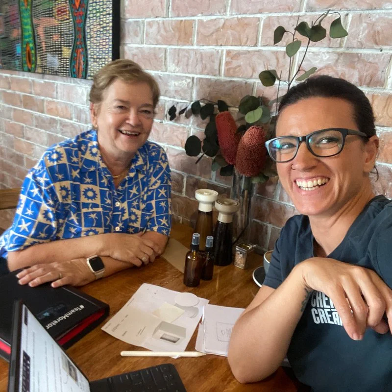 Two people seated at a table during a creative consulting session discussing branding ideas