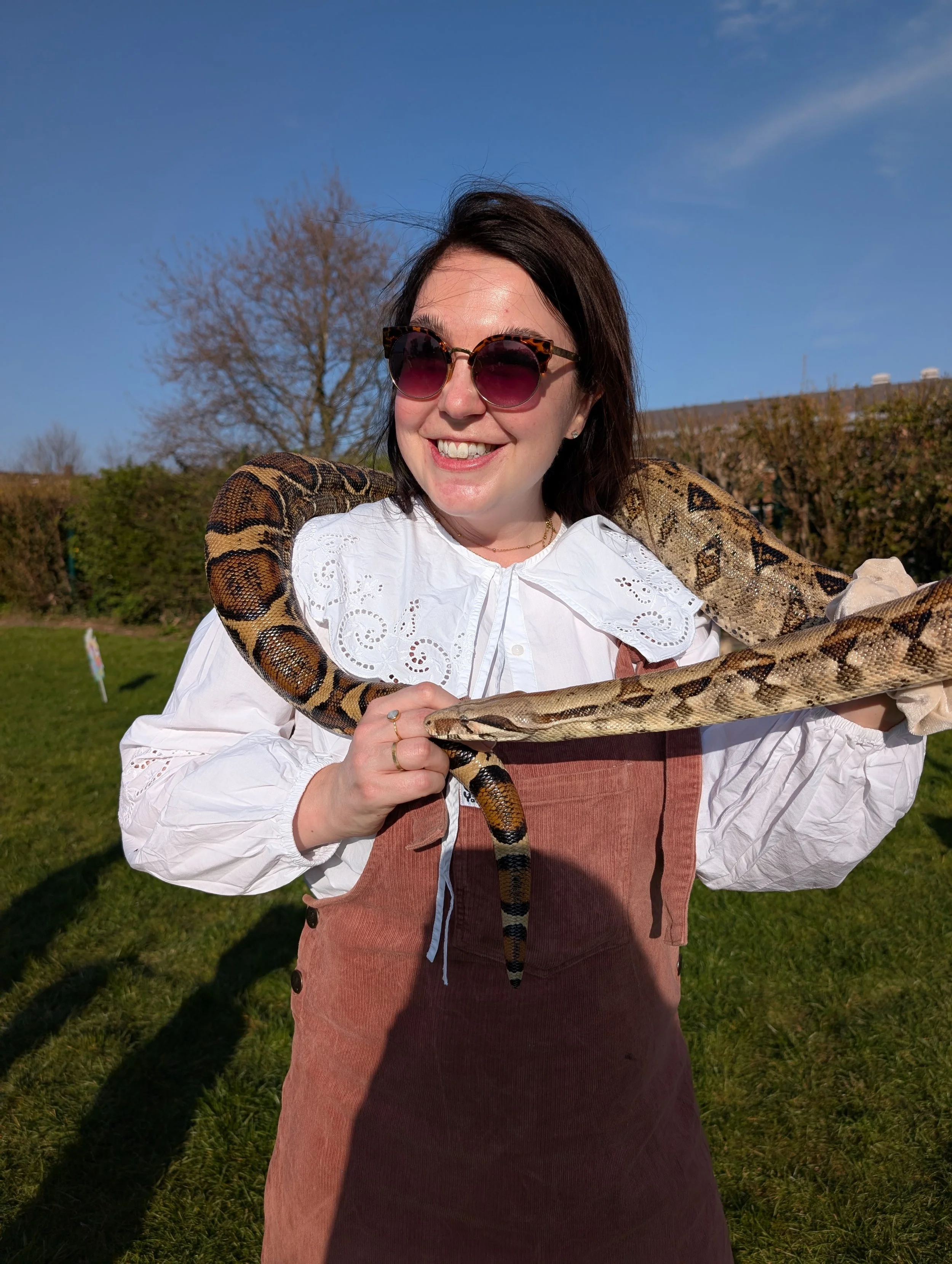 Woman wearing sunglasses with a snake around her neck