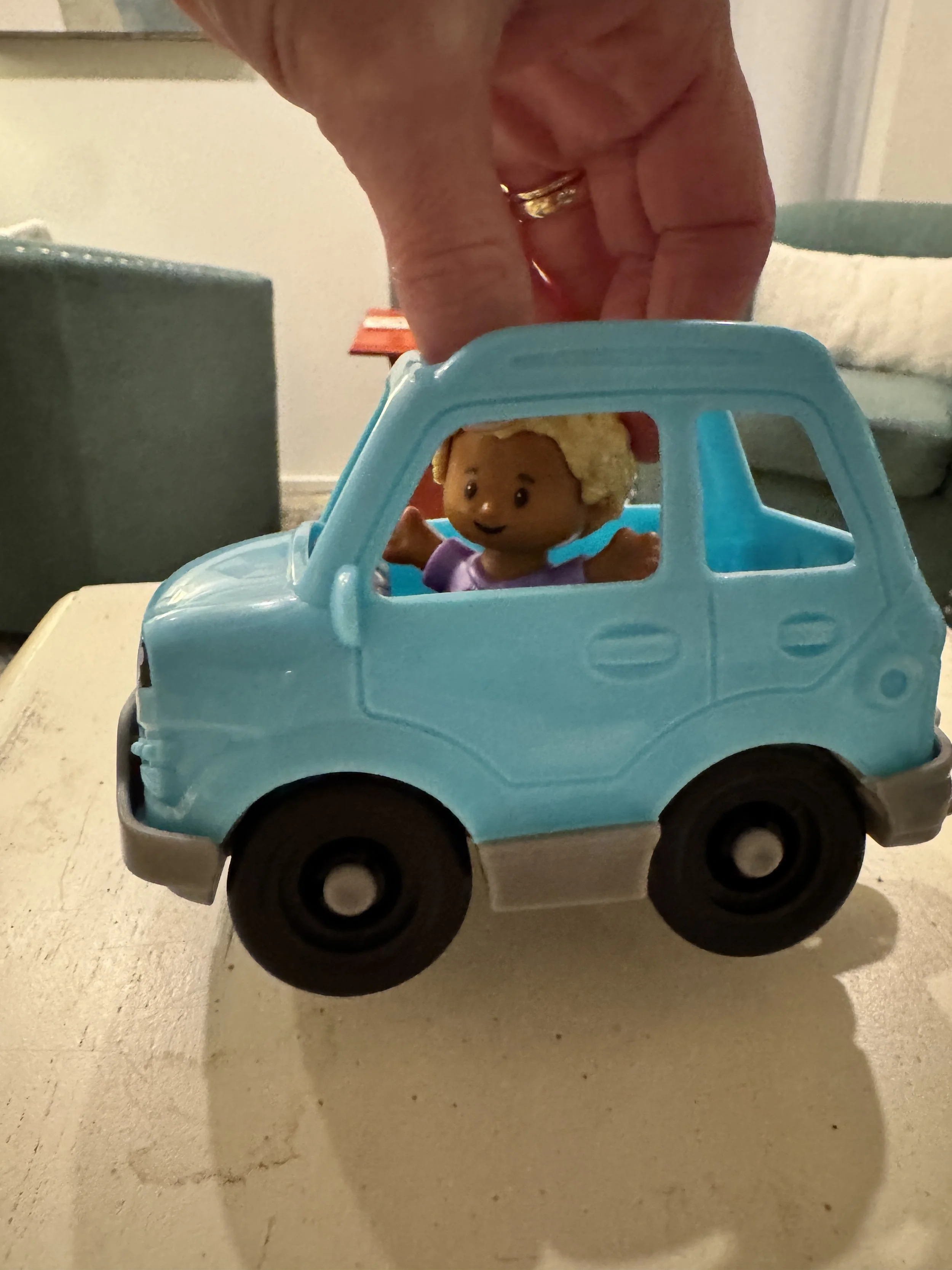 toy fisher price boy in soccer shirt driving a blue car