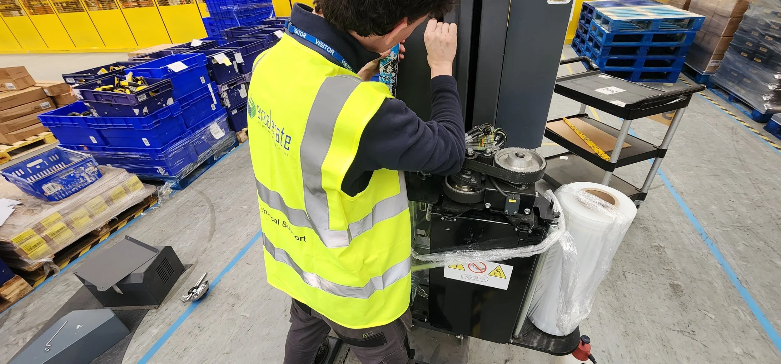 Excelerate engineer working on a broken pallet wrapper