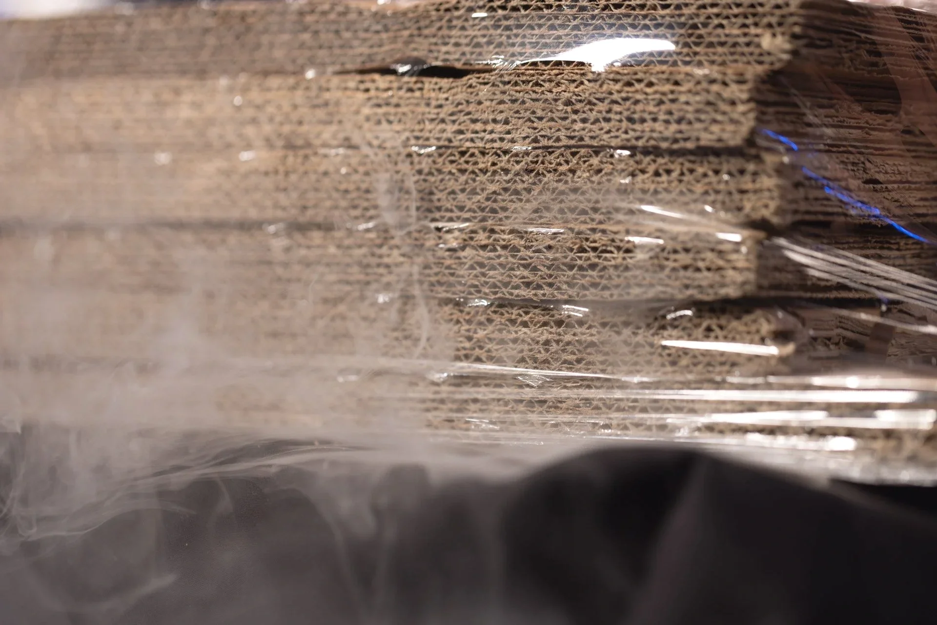 Cardboard boxes and cans protected by ExcelAir ventilated pallet wrap against moisture and damage
